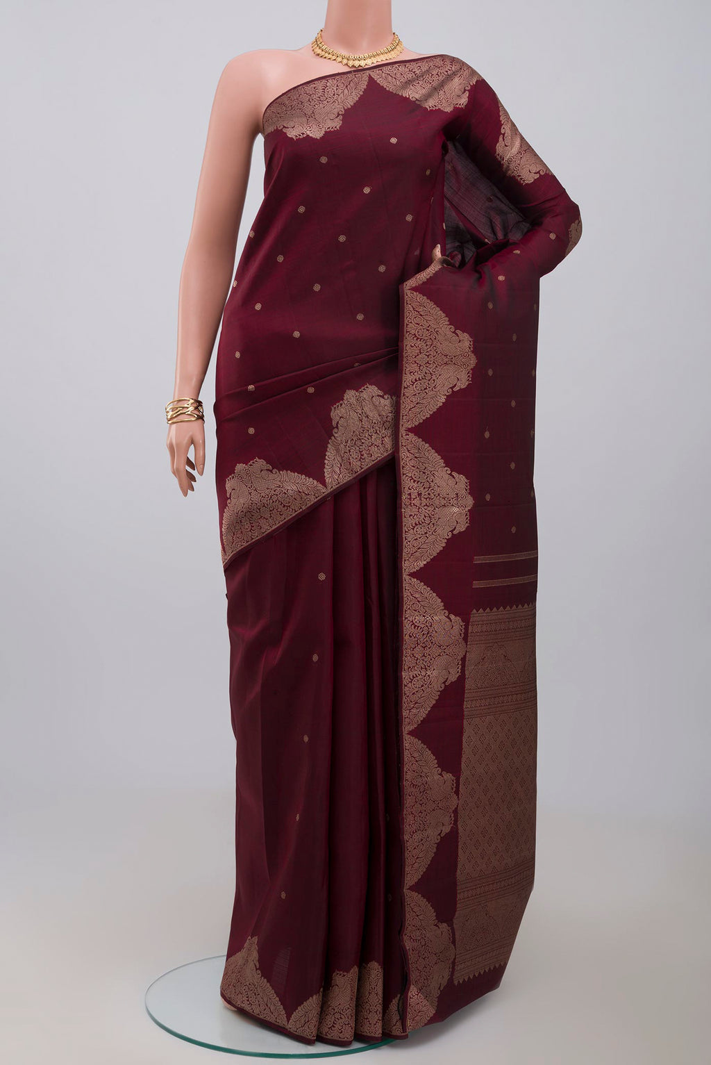 Pure Silk Pure Zari Maroon Kanjivaram Saree with Zari Butta on the body and Fancy Border.  displayed on a mannequin