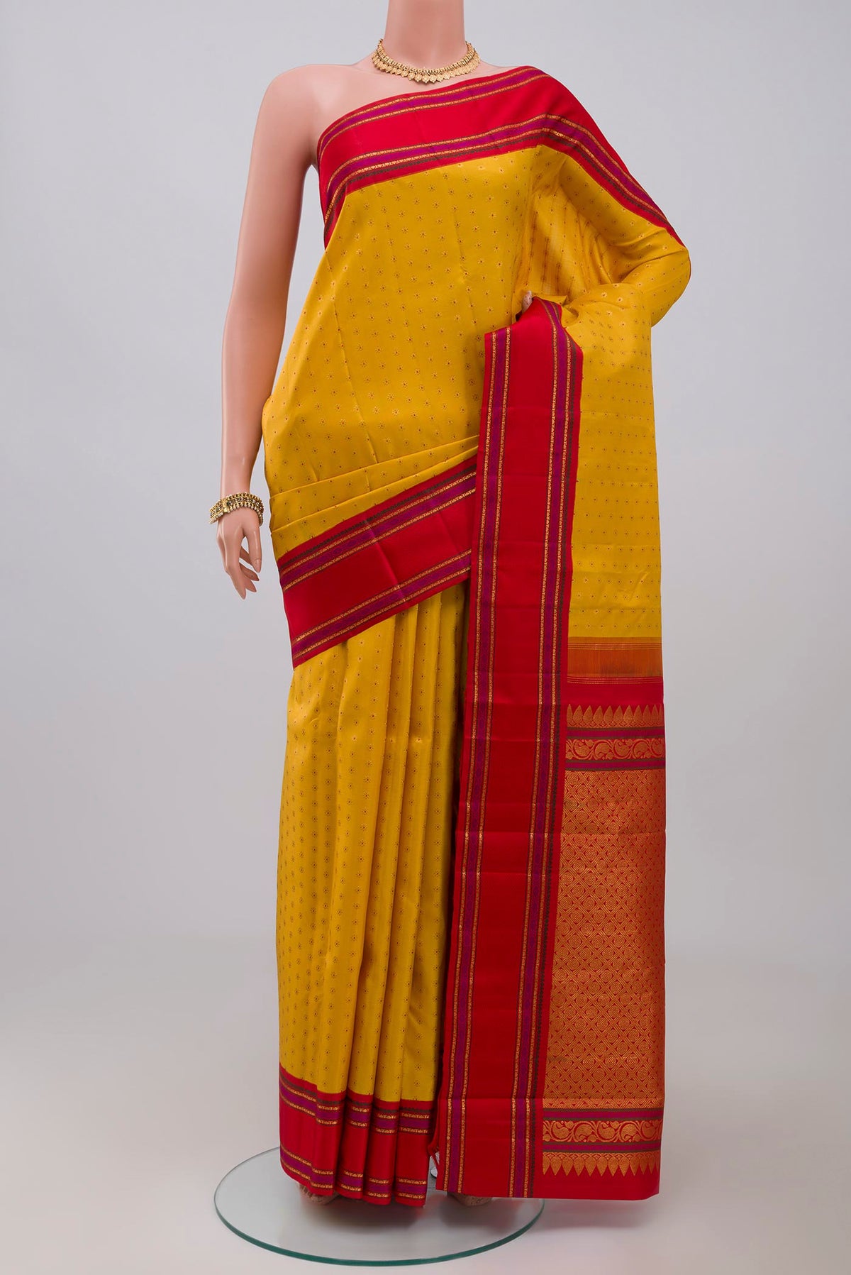 Pure Silk Pure Zari Yellow Kanchipuram Saree with Zari Butta on the body and Zari And Thread Border.  displayed on a mannequin