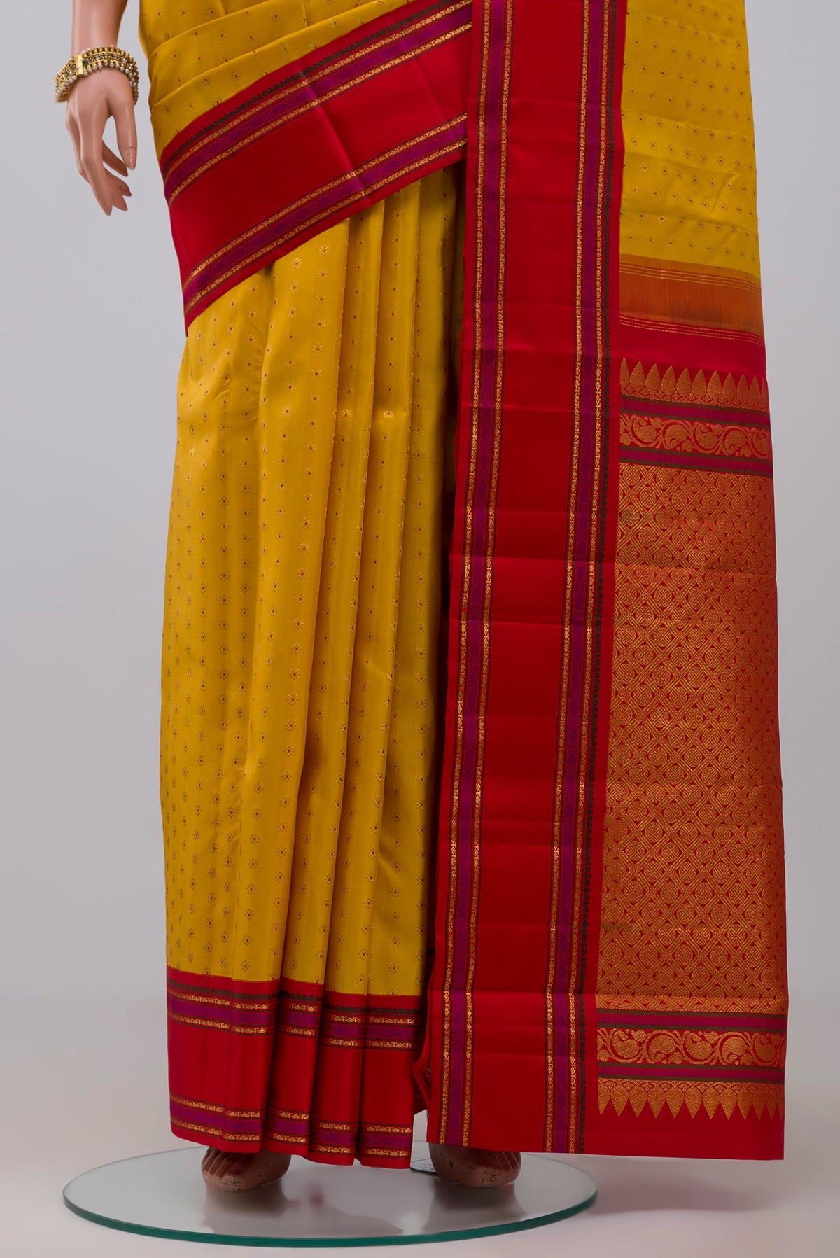 Pleats and pallu of Pure Silk Pure Zari Yellow Kanchipuram Saree with Zari Butta on the body and Zari And Thread Border. 