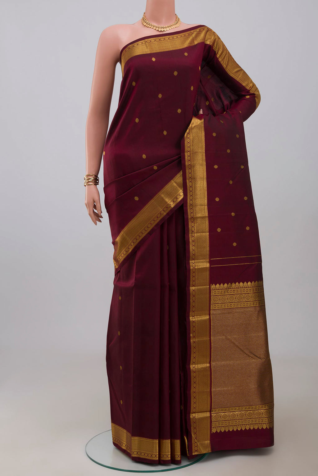 Pure Silk Pure Zari Maroon Kanchipuram Saree with Zari Butta on the body and Zari Border.  displayed on a mannequin