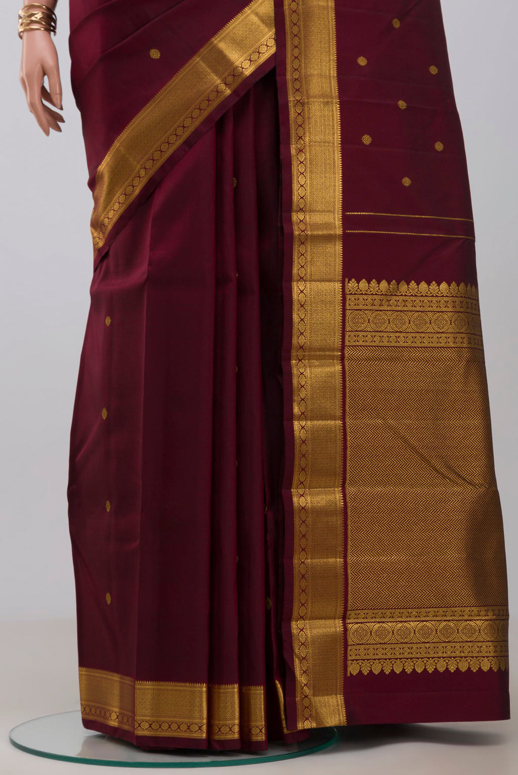 Pleats and pallu of Pure Silk Pure Zari Maroon Kanchipuram Saree with Zari Butta on the body and Zari Border. 