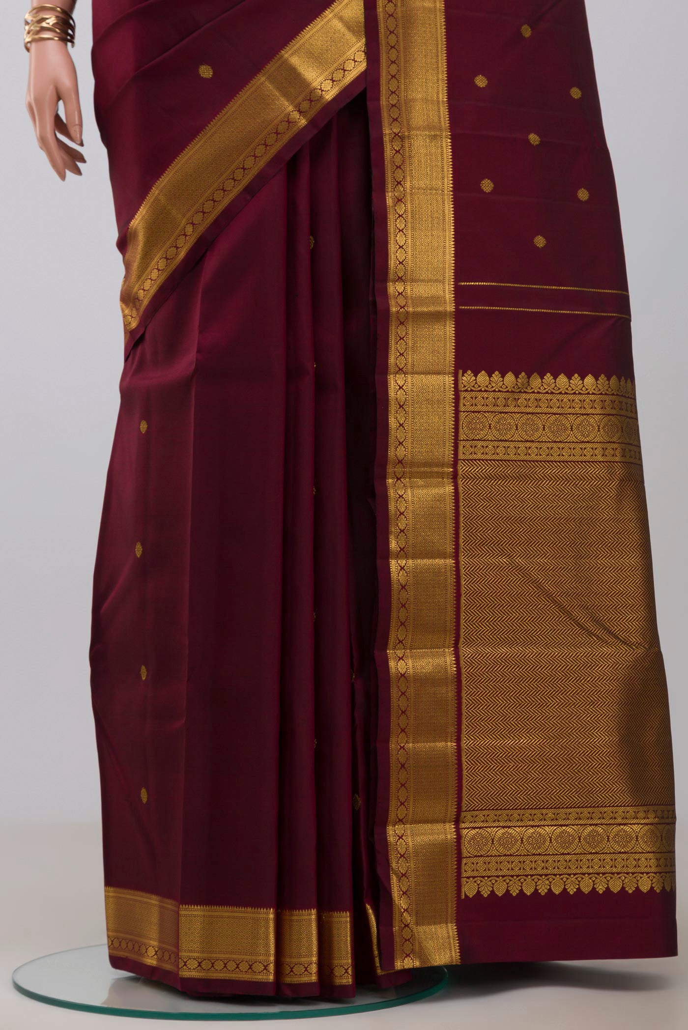 Pleats and pallu of Pure Silk Pure Zari Maroon Kanchipuram Saree with Zari Butta on the body and Zari Border. 
