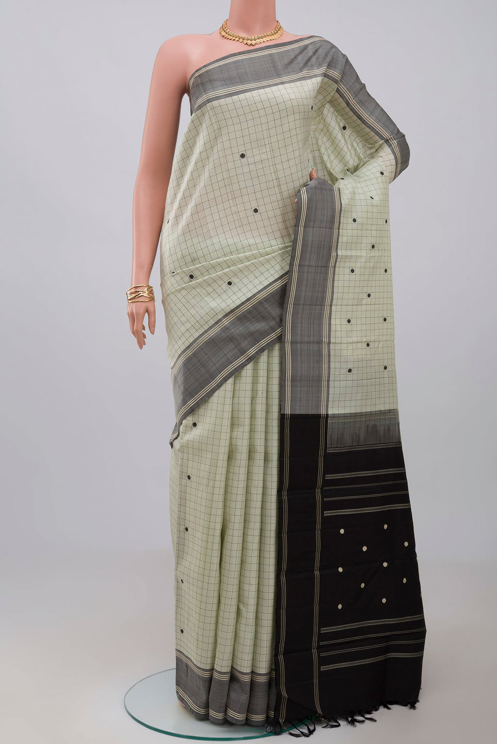 Pista Green Kanjivaram Saree with Checked design on the body and Plain Border.  displayed on a mannequin