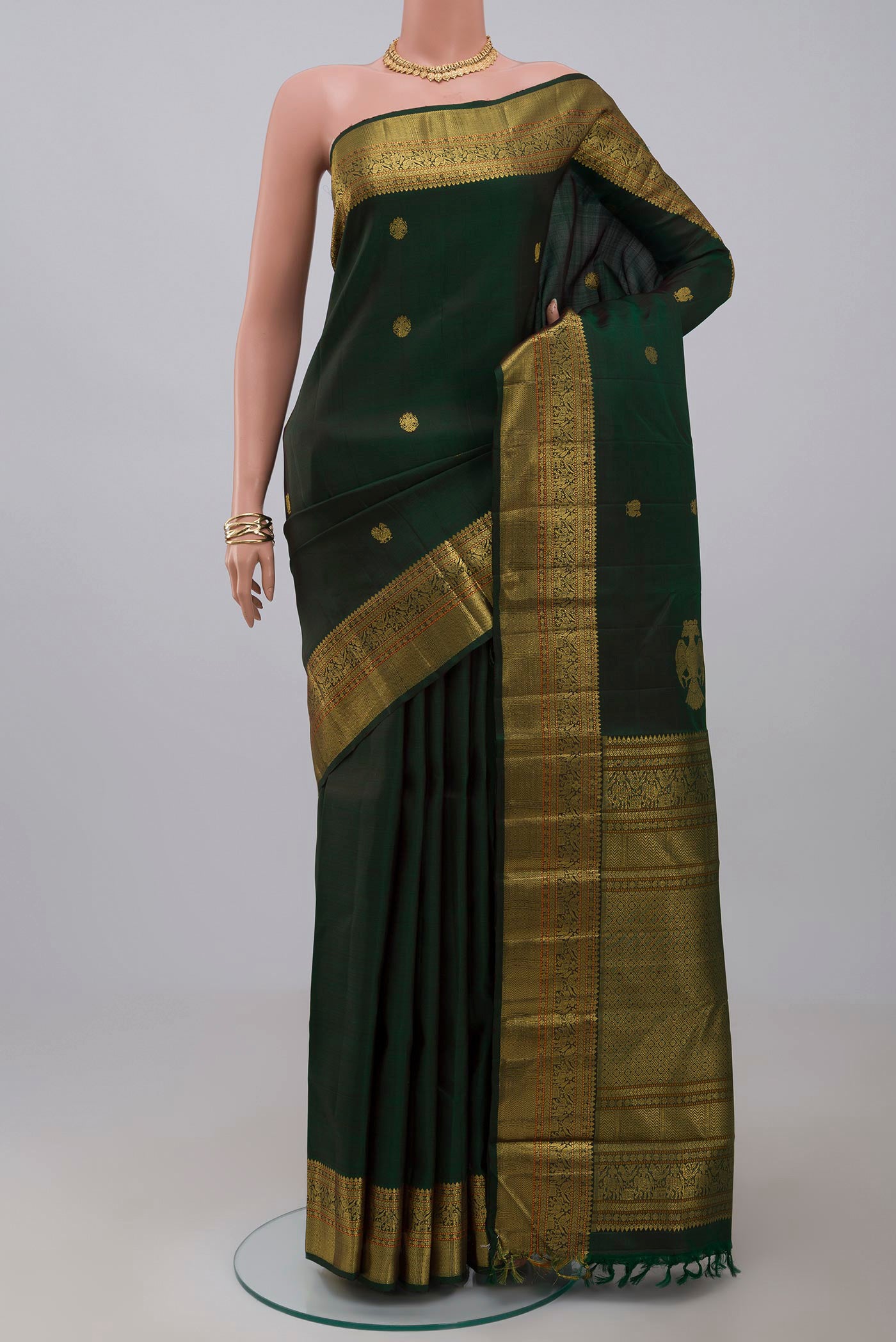 Pure Silk Pure Zari Green Kanjivaram Saree with Zari Butta on the body and Zari Border.  displayed on a mannequin