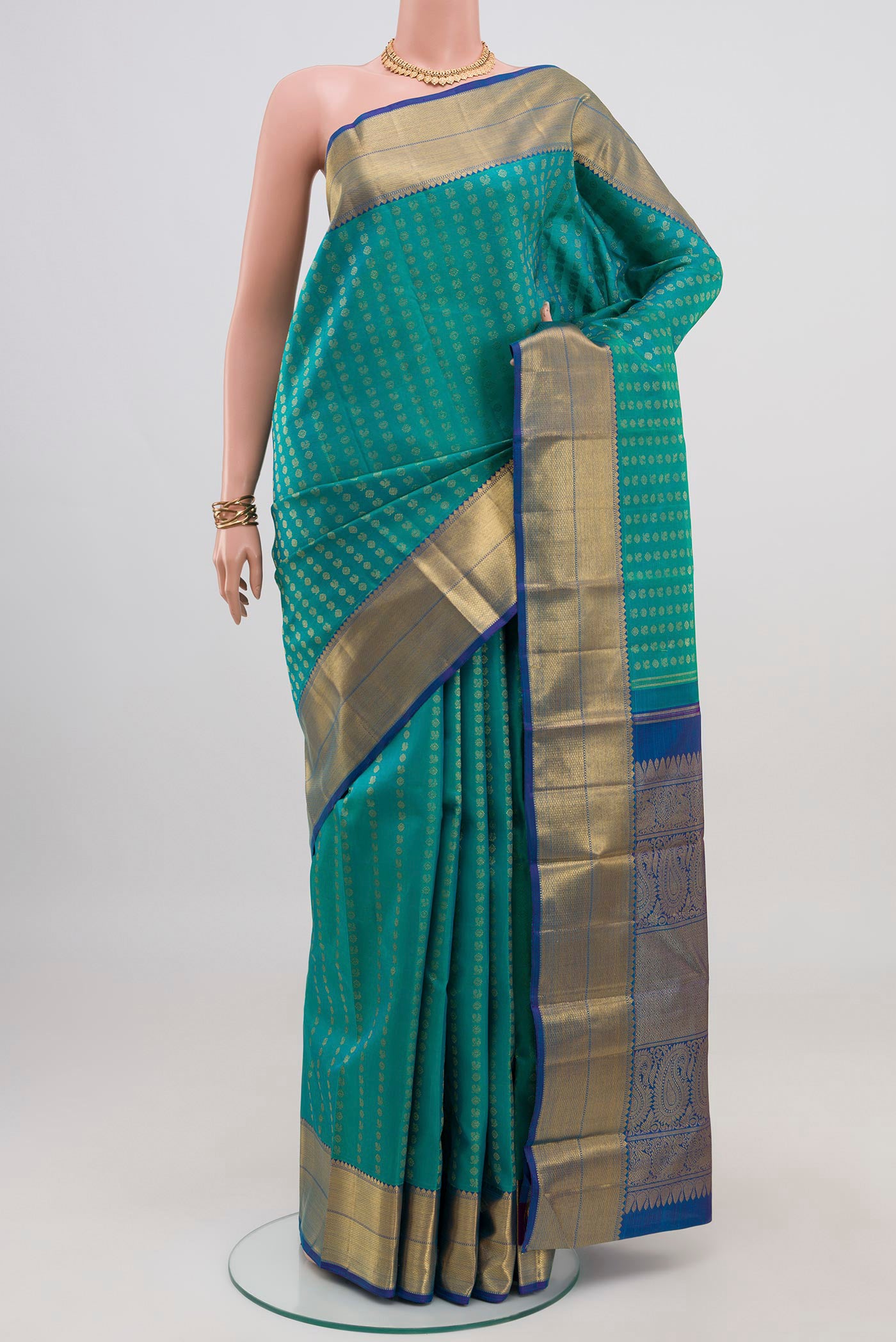 Pure Silk Pure Zari Green Dual Tone Kanjivaram Saree with Zari Butta on the body and Zari Border.  displayed on a mannequin