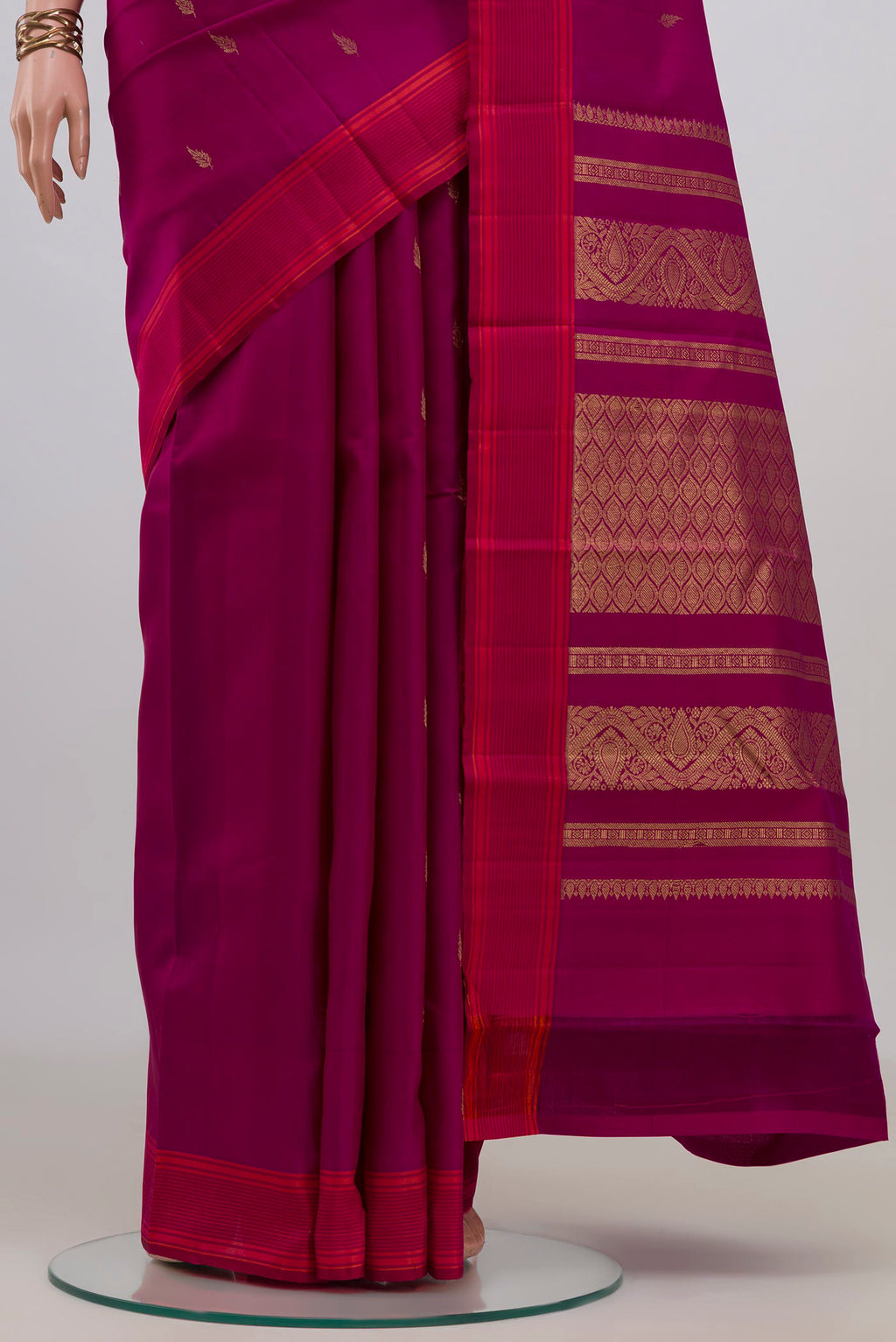 Pleats and pallu of Pure Silk Magenta Kanchipuram Saree with Zari Butta on the body and Plain Border. 