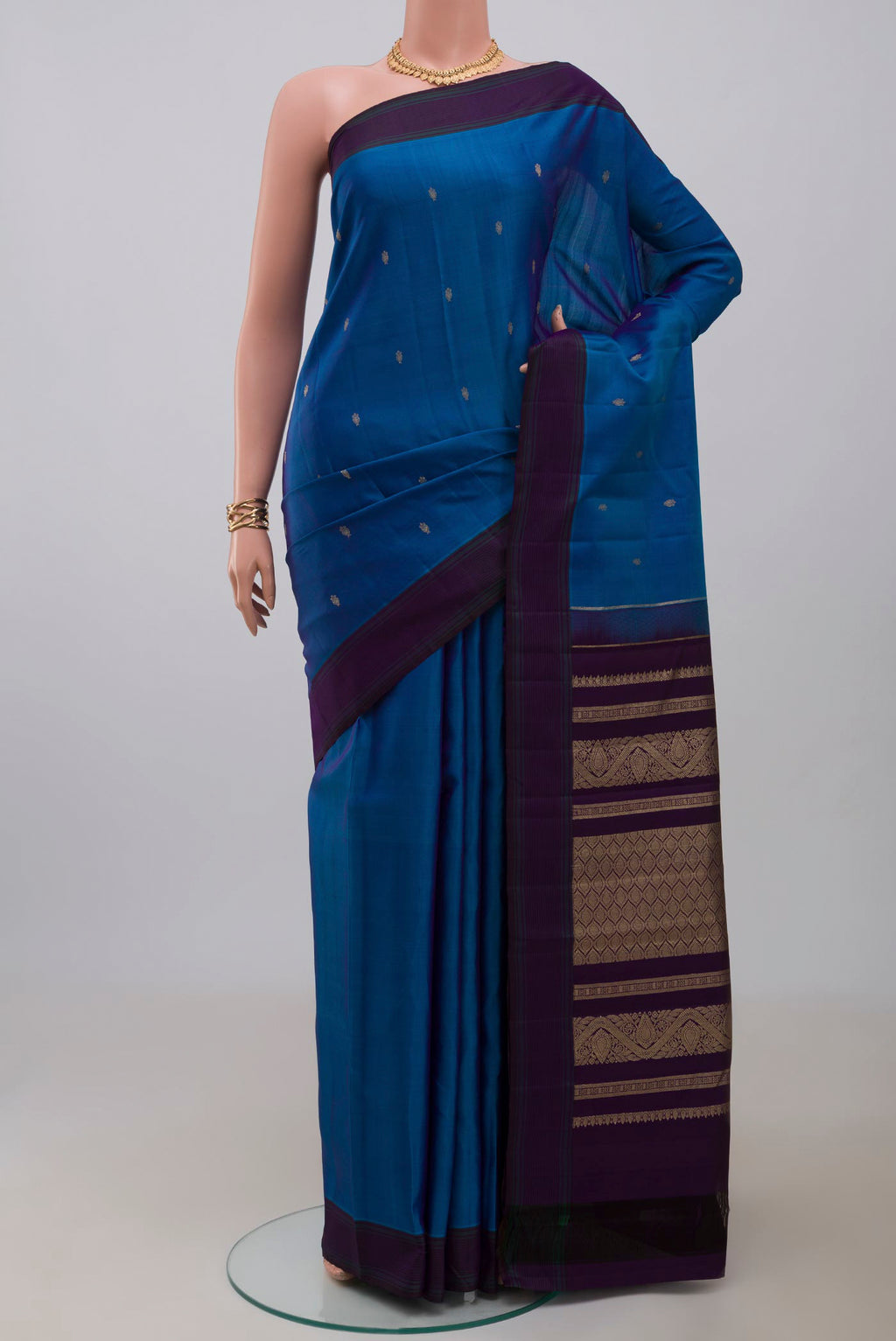 Blue Kanchipuram Silk Saree with Zari Butta on the body and Plain Border.  displayed on a mannequin