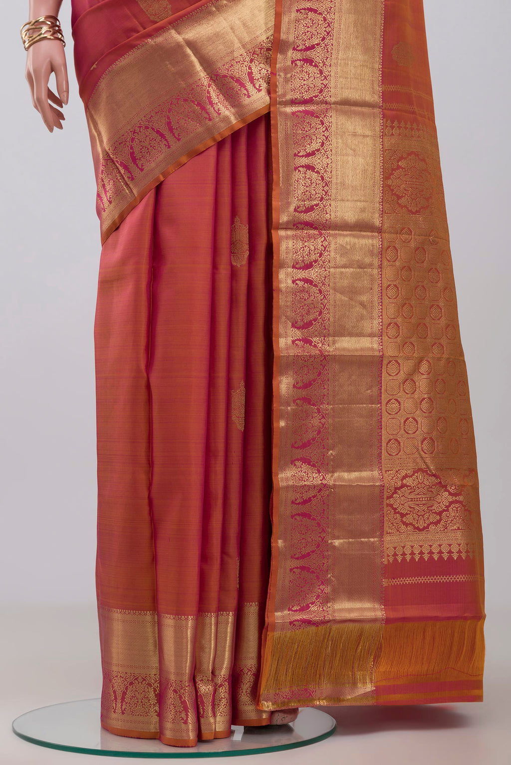 Pleats and pallu of Orange Kanchipuram Silk Saree with Zari Butta on the body and Zari Border. 