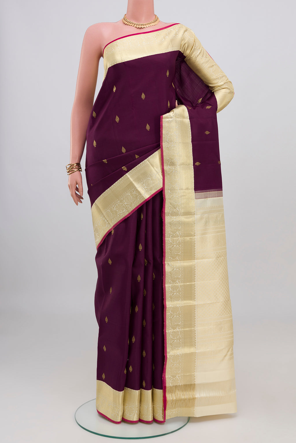 Purple Kanjivaram Silk Saree with Zari Butta on the body and Zari Border.  displayed on a mannequin