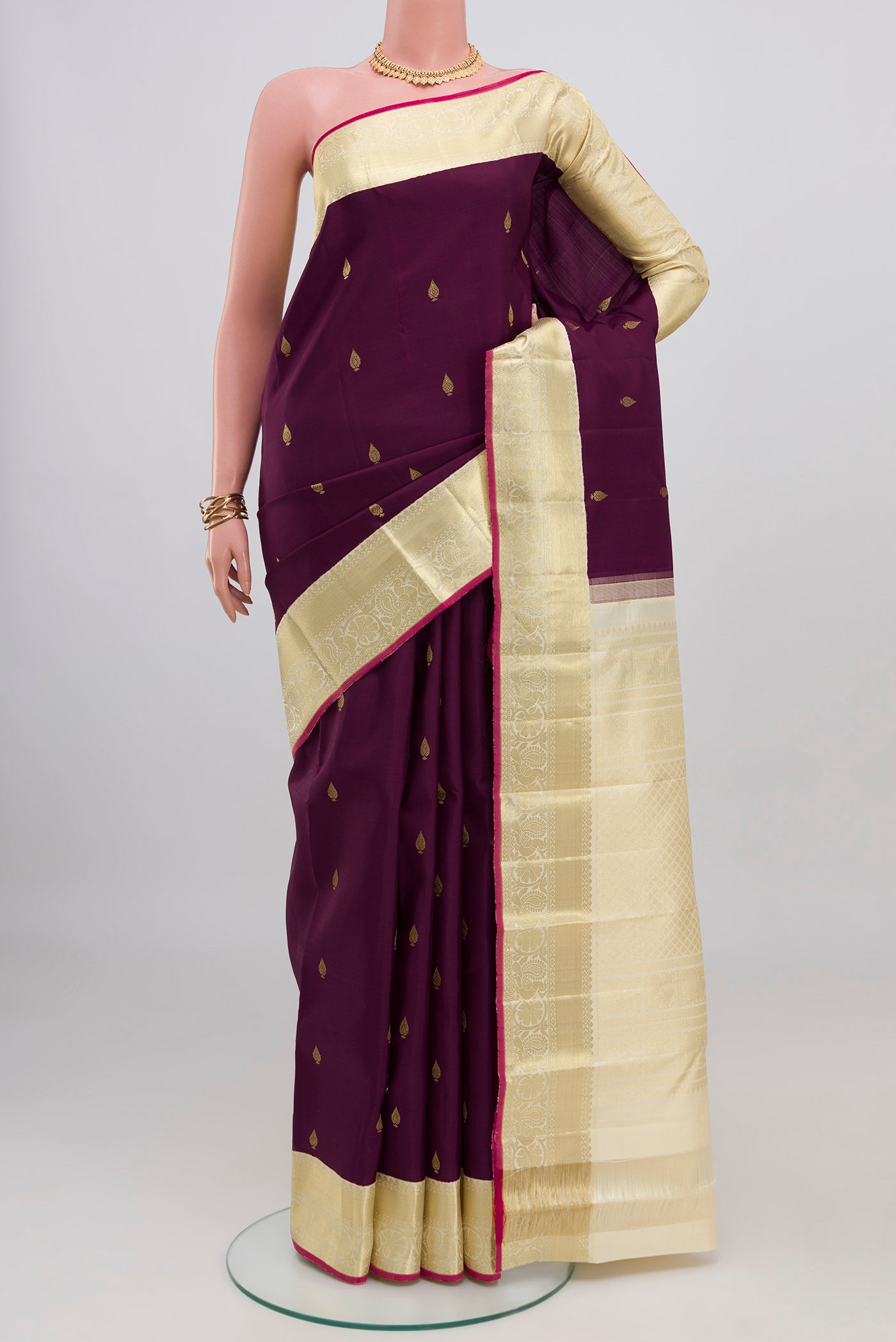 Purple Kanjivaram Silk Saree with Zari Butta on the body and Zari Border.  displayed on a mannequin