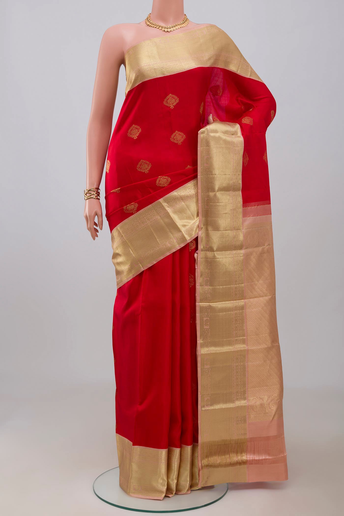 Red Kanjivaram Silk Saree with Zari Butta on the body and Zari Border.  displayed on a mannequin