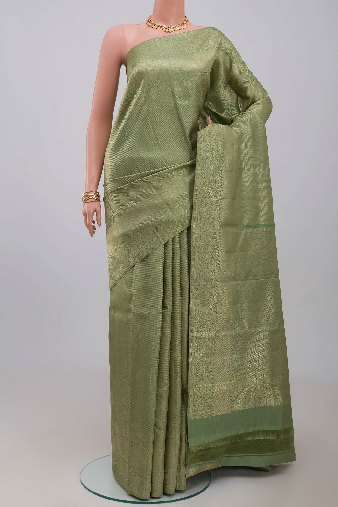 Pista Green Kanchipuram Silk Saree with Zari Brocade on the body and Zari Border.  displayed on a mannequin