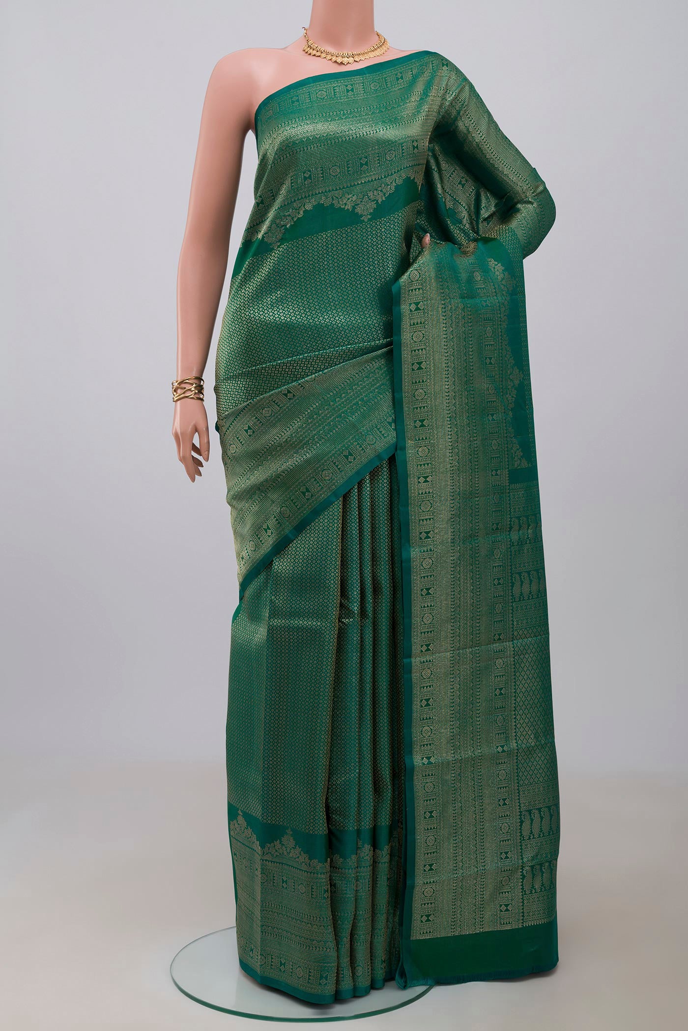 Green Kanchipuram Silk Saree with Zari Brocade on the body and Fancy Border.  displayed on a mannequin