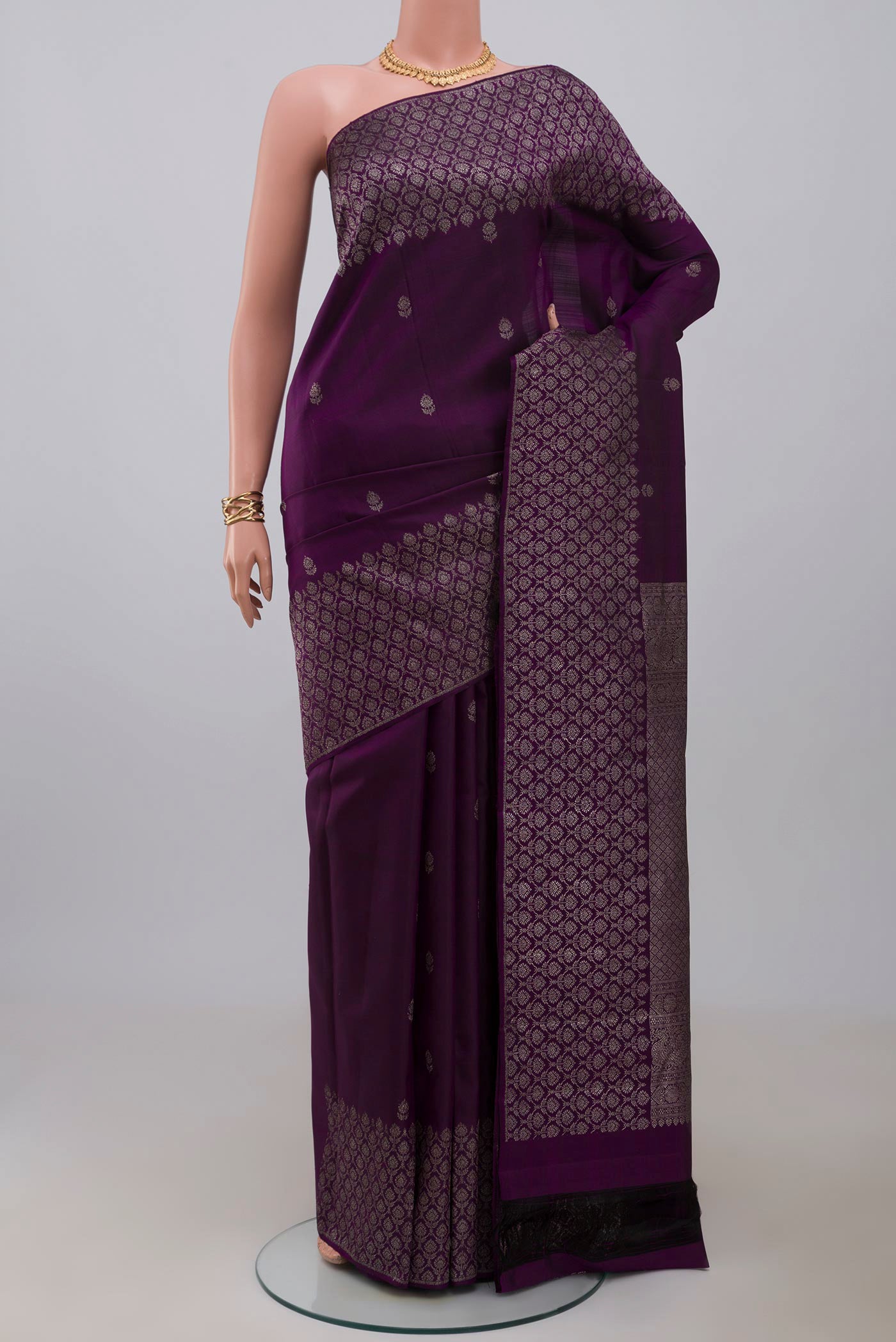 Purple Kanjivaram Silk Saree with Zari Butta on the body and Zari Border.  displayed on a mannequin