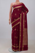 Maroon Kanjivaram Silk Saree with Zari Butta on the body and Zari Border.  displayed on a mannequin