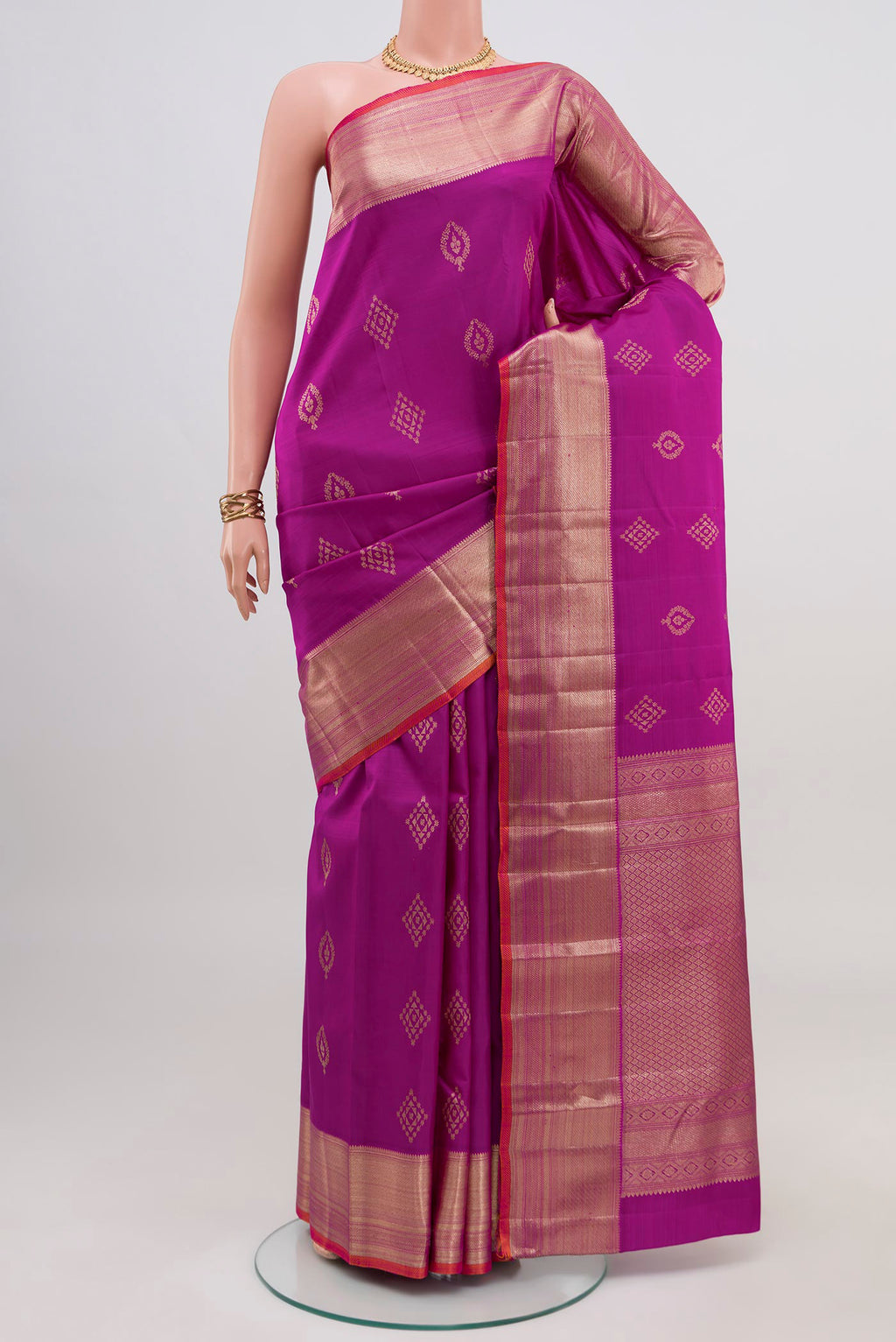 Magenta Kanjivaram Silk Saree with Zari Butta on the body and Zari Border.  displayed on a mannequin