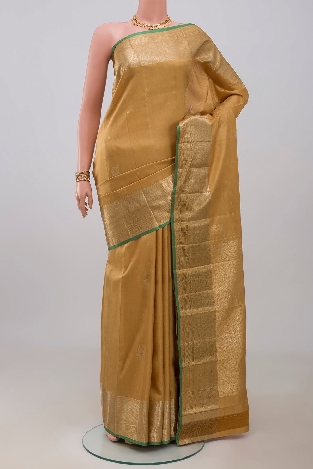 Dark Beige Kanjivaram Silk Saree with Zari Butta on the body and Zari Border.  displayed on a mannequin