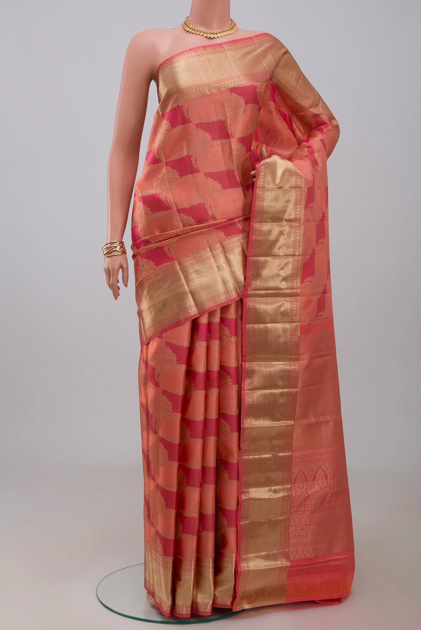 Peach Kanjivaram Silk Saree with Zari Brocade on the body and Zari Border.  displayed on a mannequin