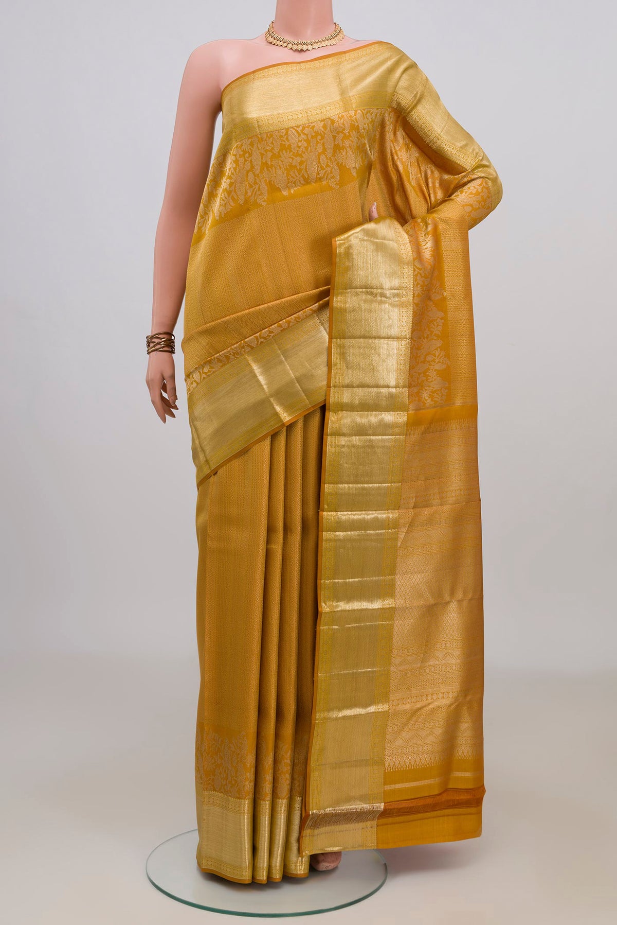 Pure Silk Mustard Kanjivaram Saree with Zari Brocade on the body and Zari Border.  displayed on a mannequin