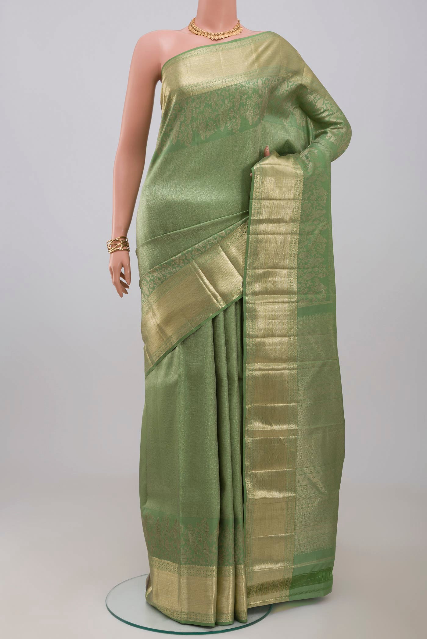 Green Kanjivaram Silk Saree with Zari Brocade on the body and Zari Border.  displayed on a mannequin