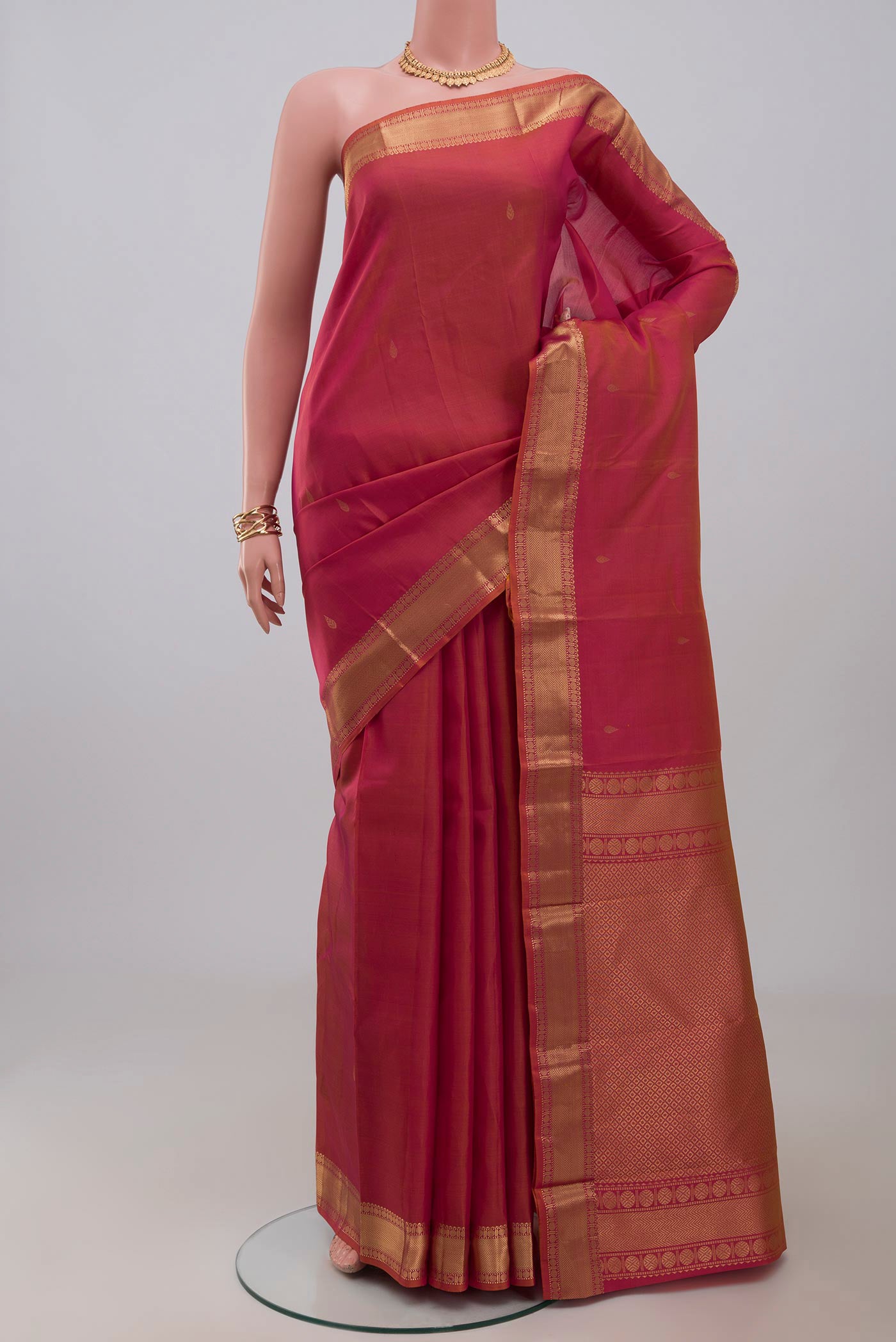 Orange Kanchipuram Silk Saree with Zari Butta on the body and Zari Border.  displayed on a mannequin