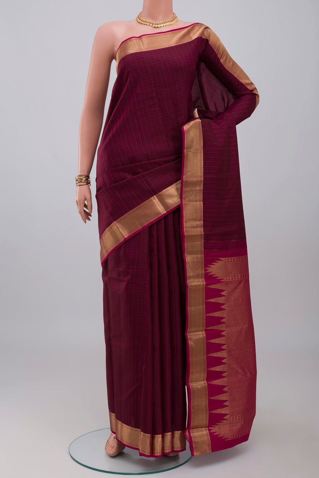Maroon Kanchipuram Silk Saree with Checked design on the body and Zari Border.  displayed on a mannequin
