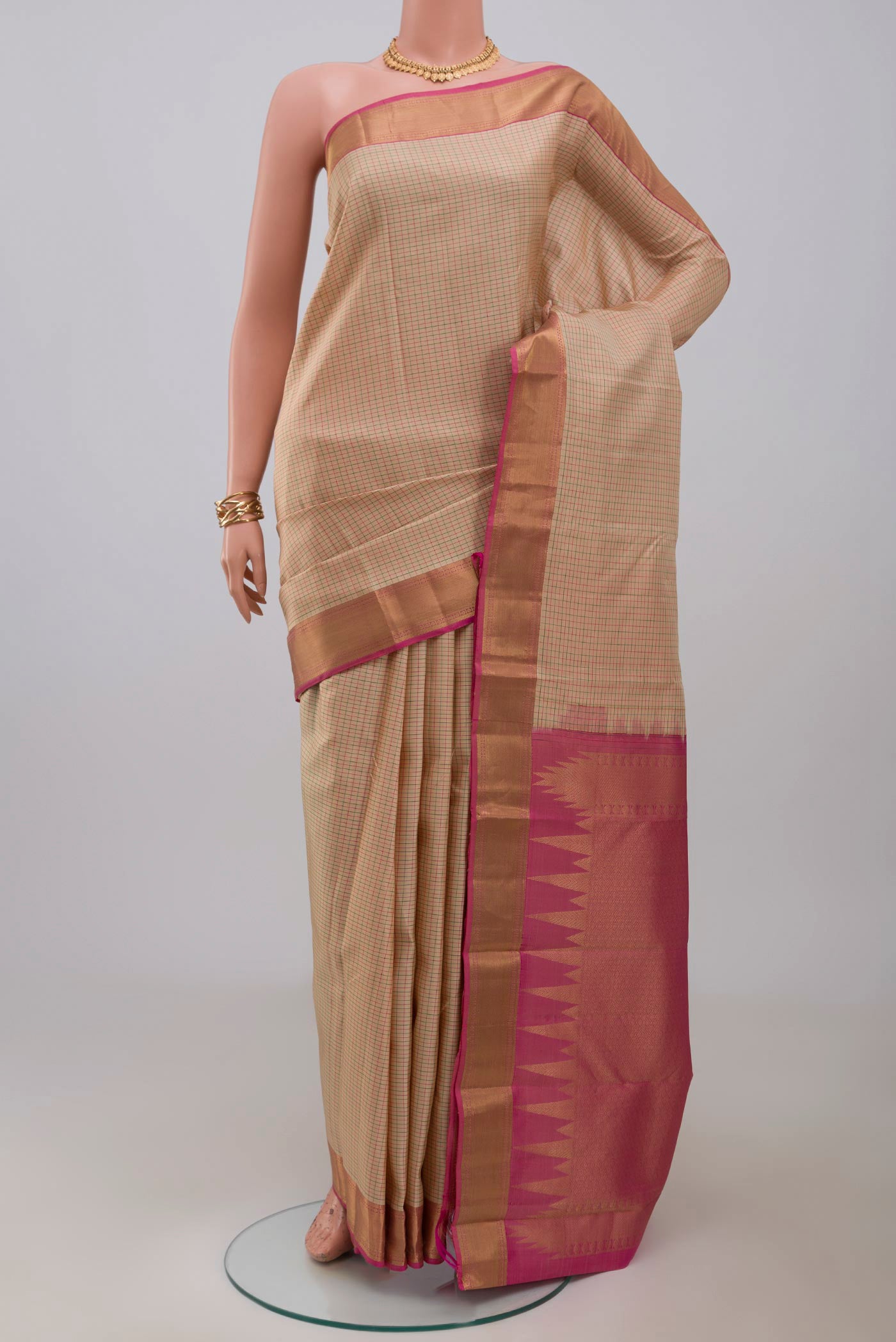 Cream Kanchipuram Saree with Checked design on the body and Zari Border.  displayed on a mannequin