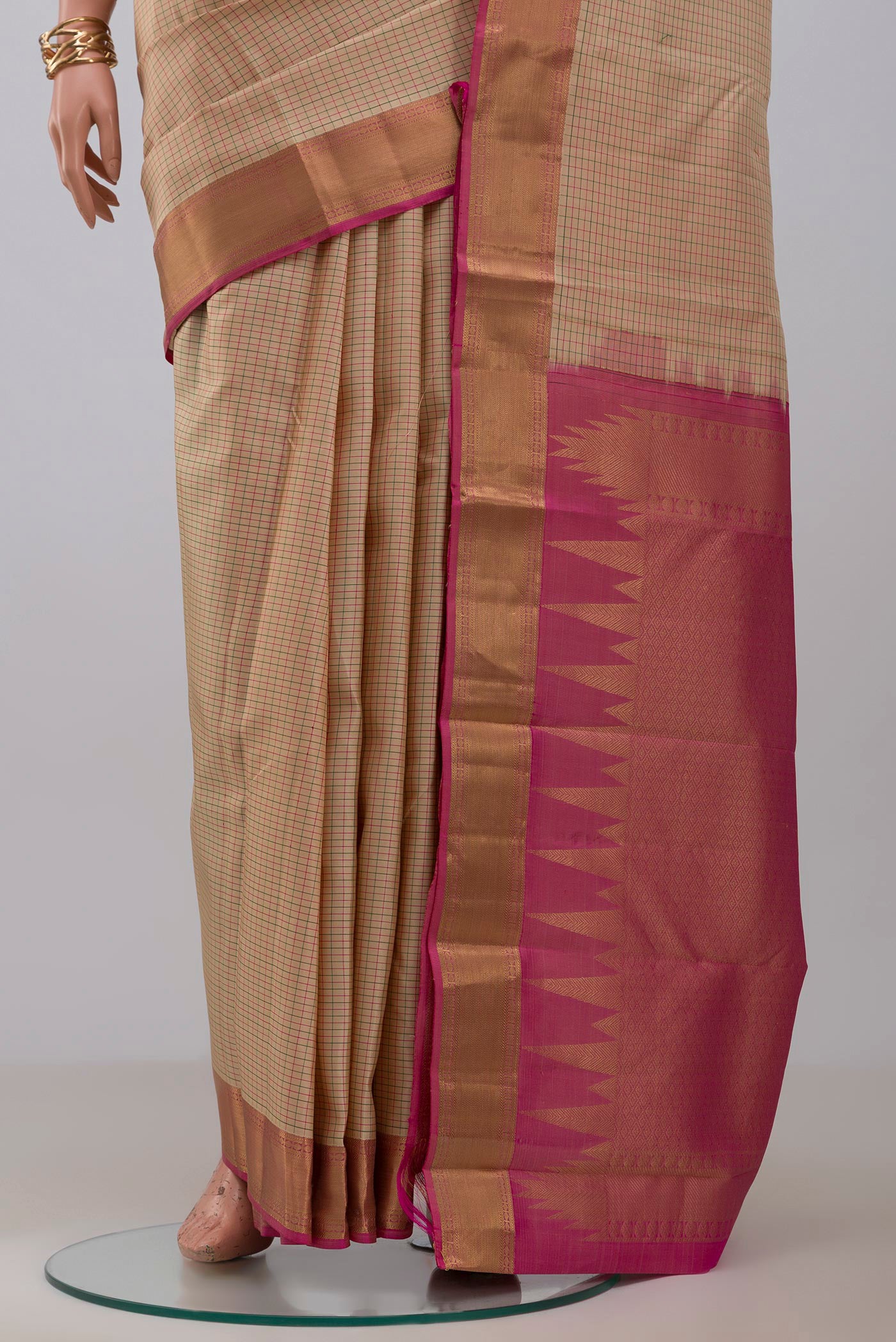 Pleats and pallu of Cream Kanchipuram Saree with Checked design on the body and Zari Border. 