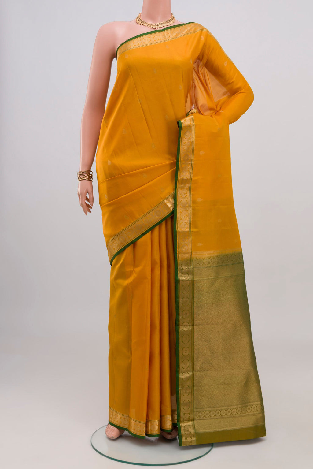 Yellow Kanchipuram Silk Saree with Zari Butta on the body and Zari Border.  displayed on a mannequin