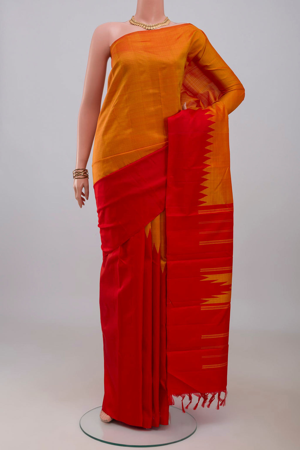 Orange Kanchipuram Silk Saree with Plain Body and Rising Temple Border.  displayed on a mannequin
