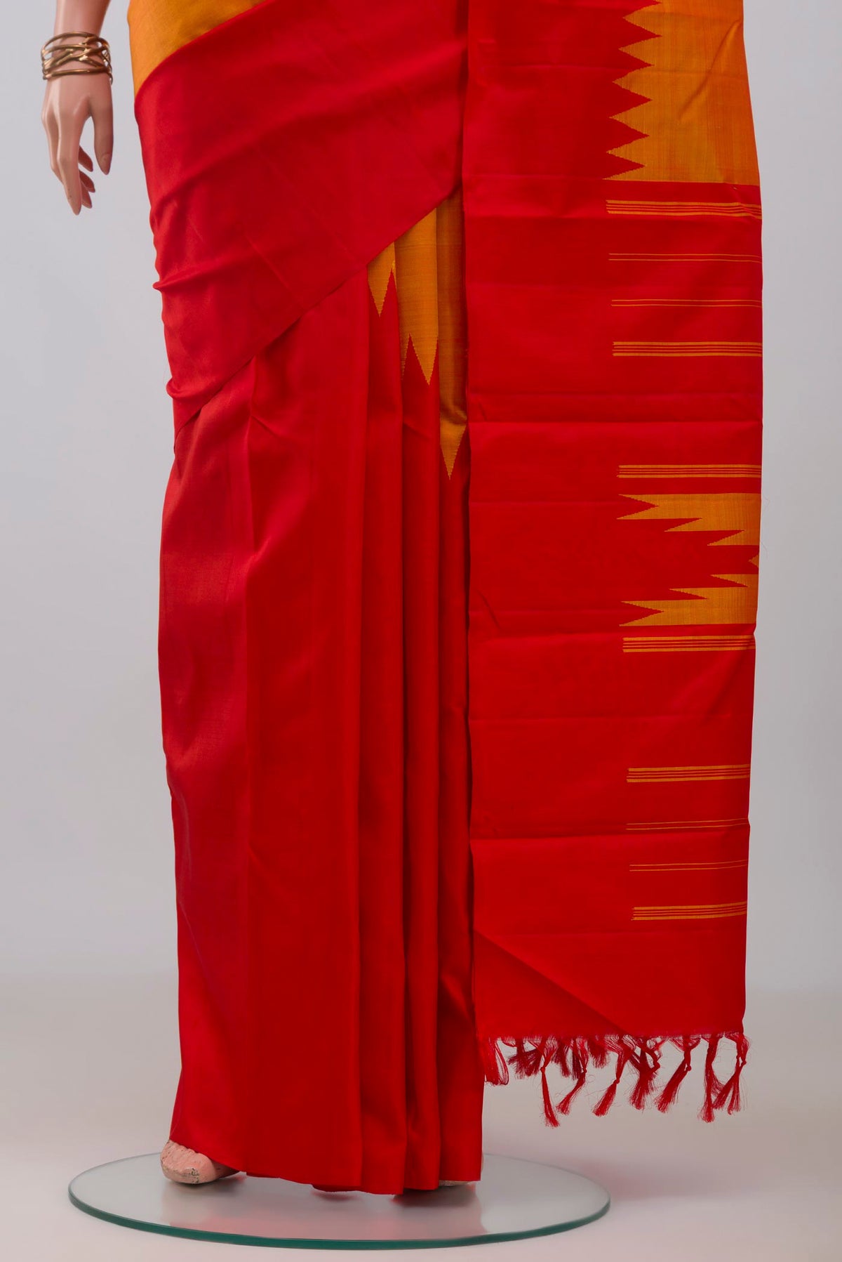 Pleats and pallu of Orange Kanchipuram Silk Saree with Plain Body and Rising Temple Border. 