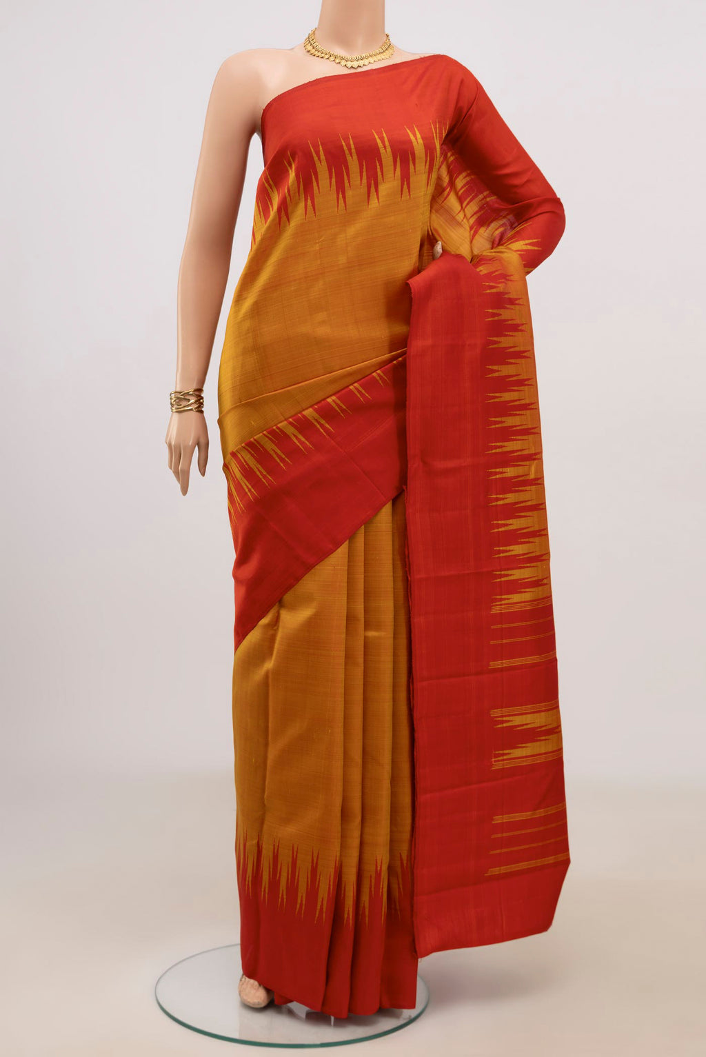 Mustard Kanjivaram Silk Saree with Plain Body and Temple Border.  displayed on a mannequin