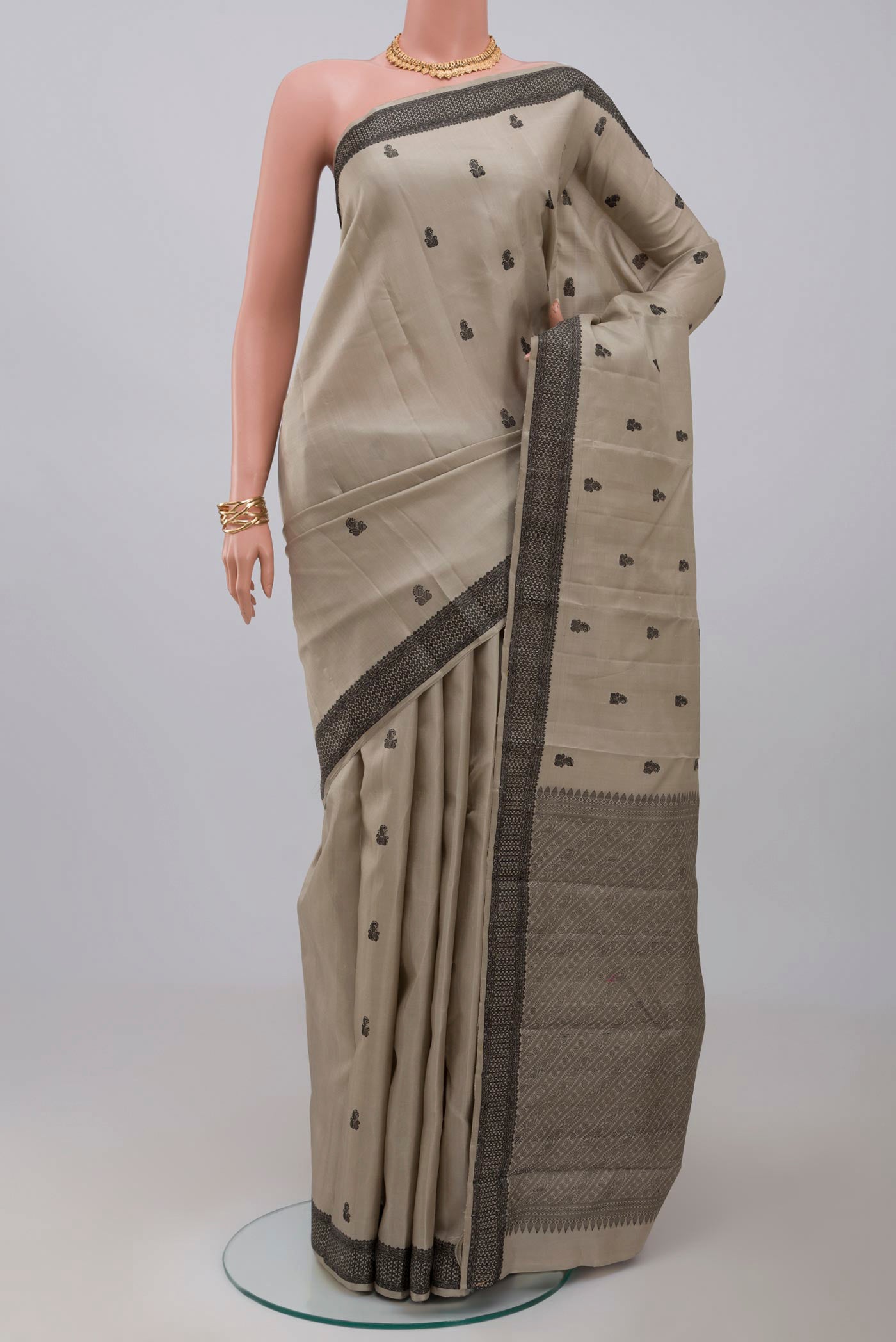 Grey Kanchipuram Saree with Thread Butta on the body and Thread Border.  displayed on a mannequin