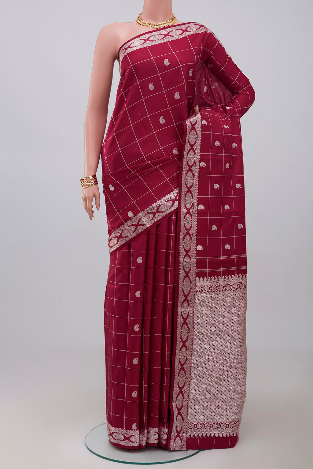 Maroon Kanjivaram Saree with Checked design on the body and Thread Border.  displayed on a mannequin