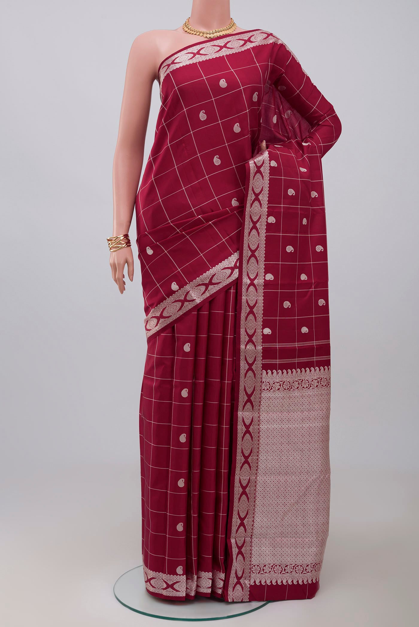 Maroon Kanjivaram Saree with Checked design on the body and Thread Border.  displayed on a mannequin