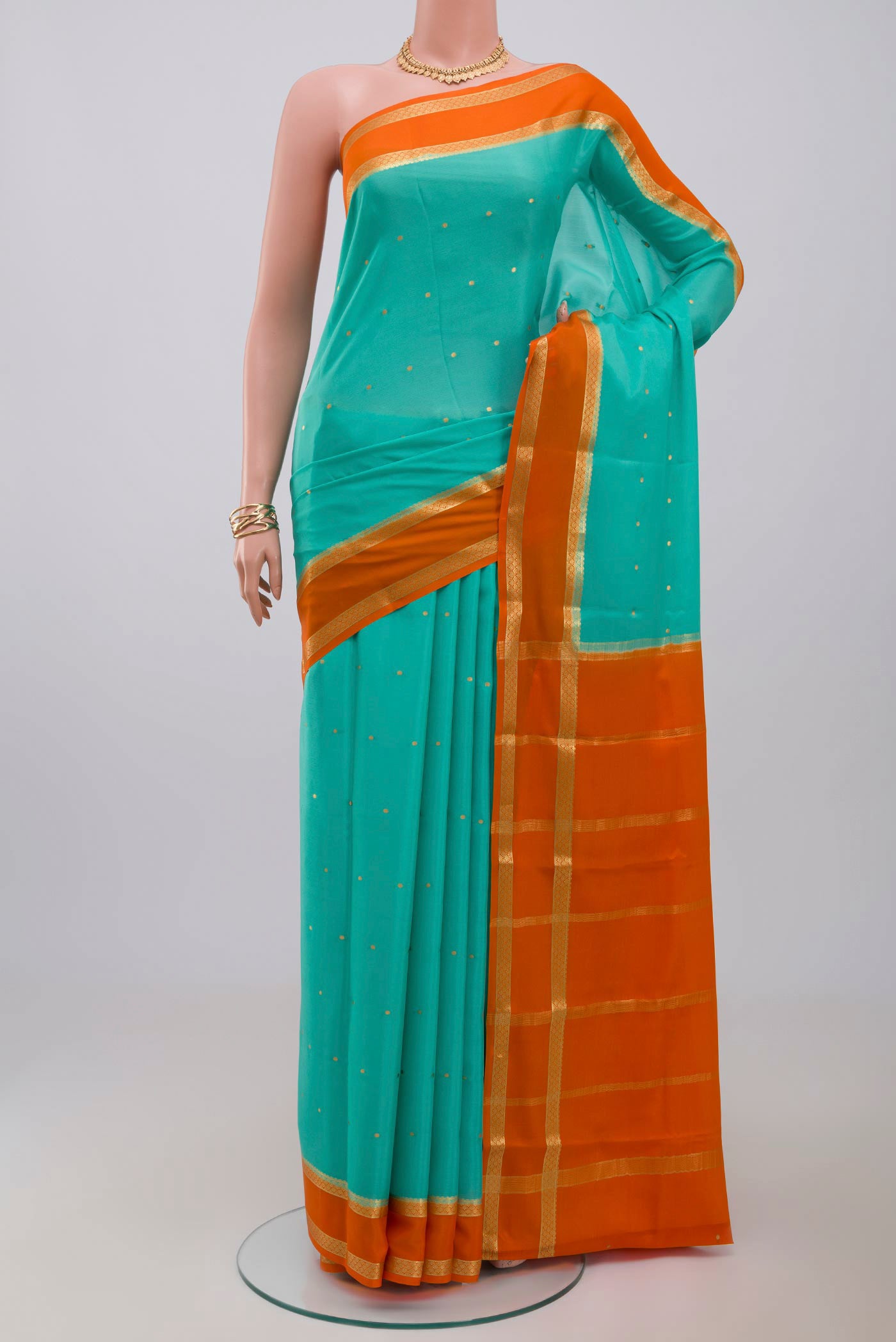 Sky Blue Crepe Saree with Zari Butta on the body and Zari Border.  displayed on a mannequin