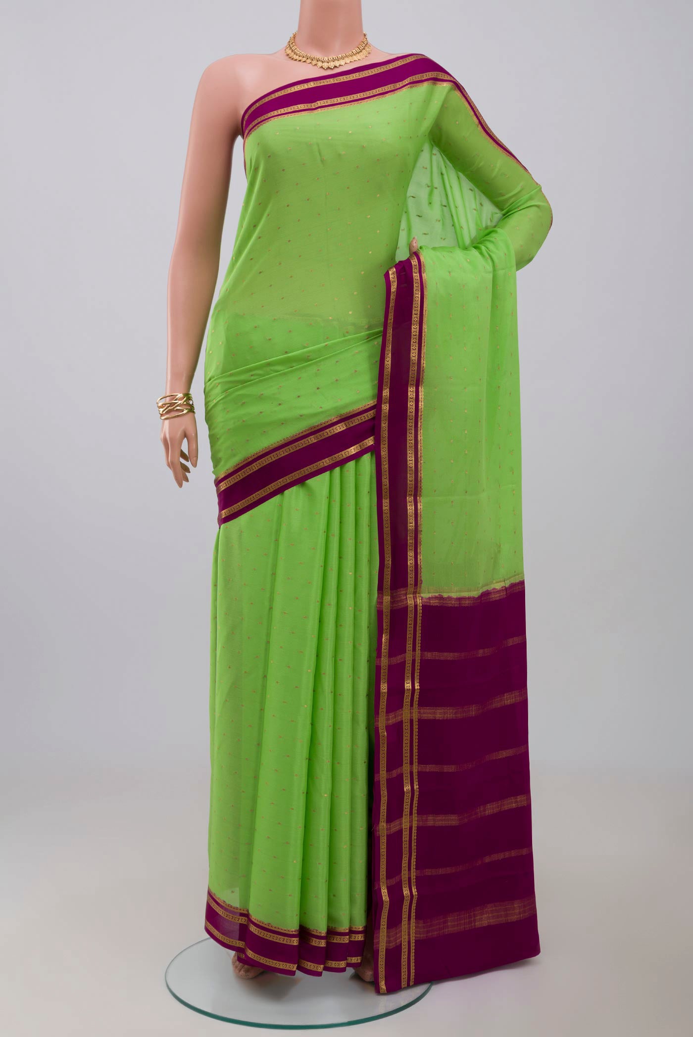 Green Crepe Saree with Zari Butta on the body and Zari Border.  displayed on a mannequin