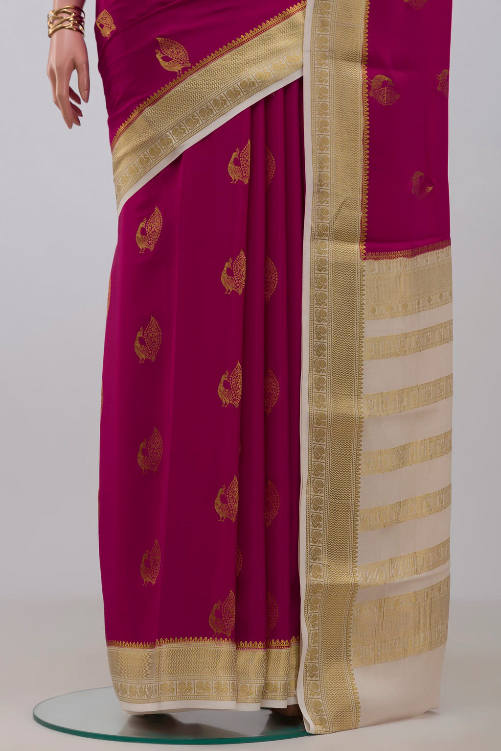 Pleats and pallu of Rani Pink Mysore Crepe Saree with Zari Butta on the body and Zari Border. 