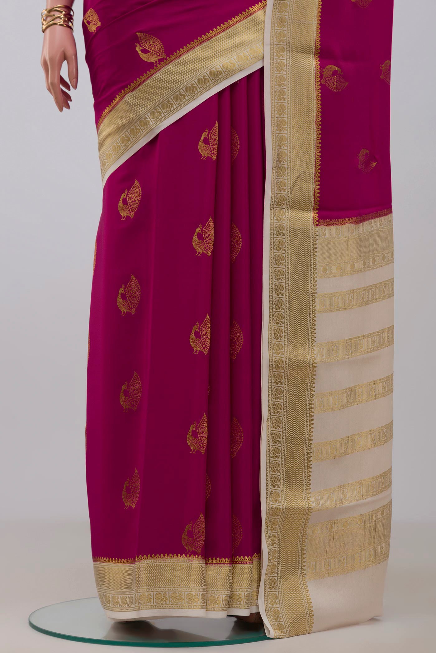 Pleats and pallu of Rani Pink Mysore Crepe Saree with Zari Butta on the body and Zari Border. 