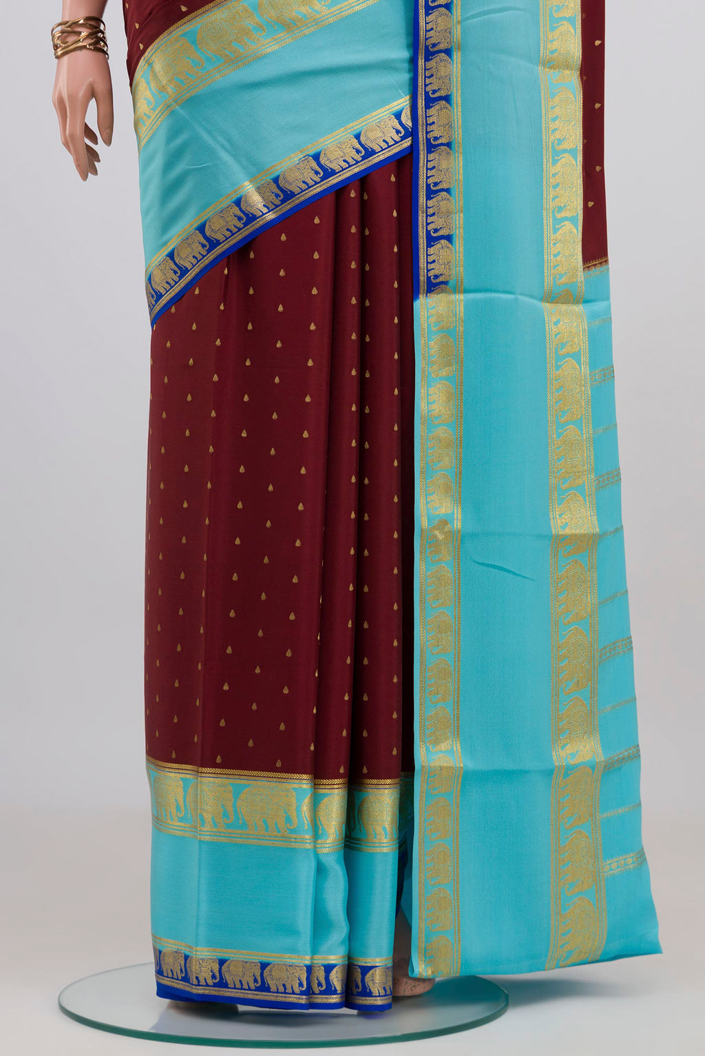Pleats and pallu of Maroon Mysore Crepe Saree with Zari Butta on the body and Zari Border. 