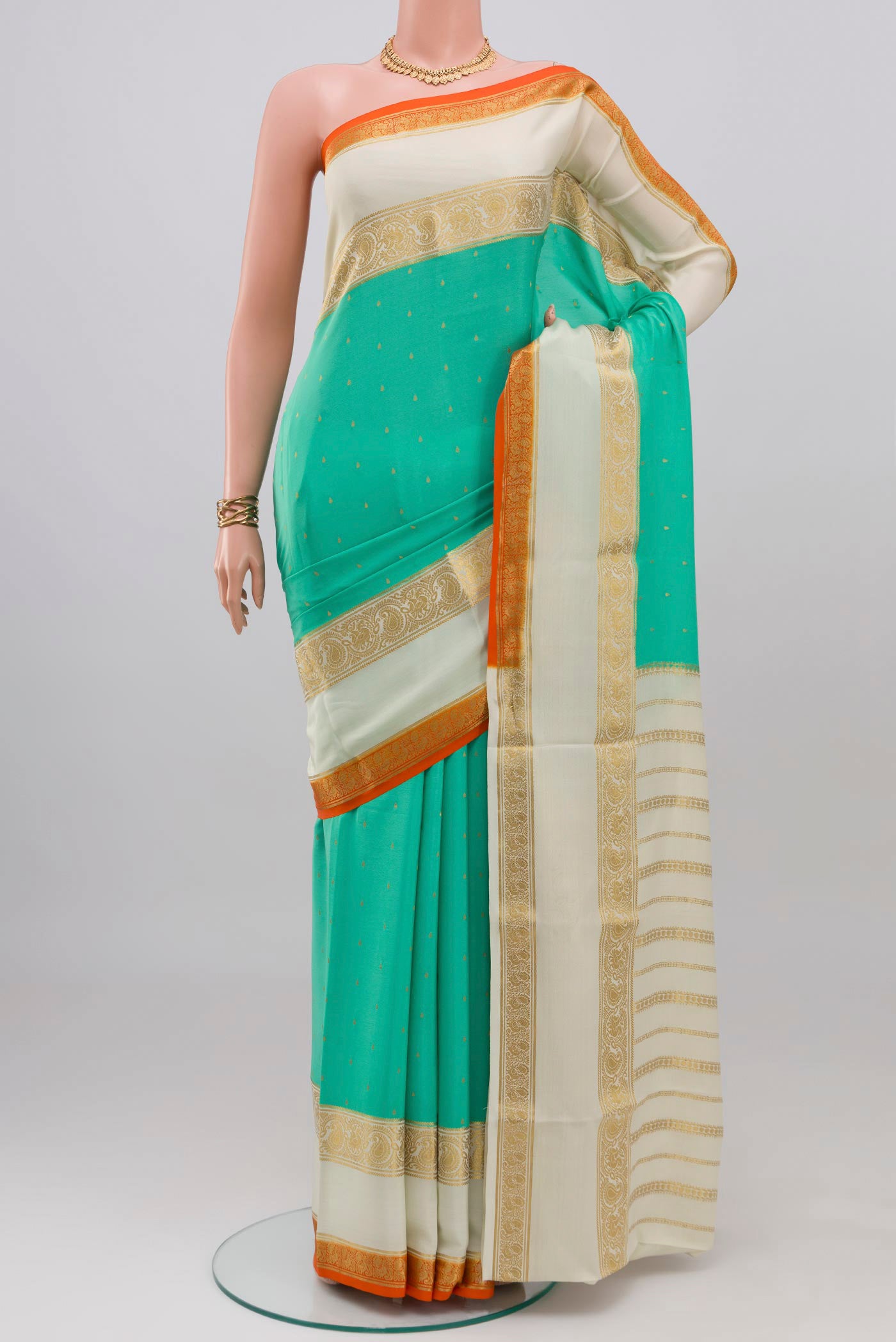 Turquoise Mysore Crepe Saree with Zari Butta on the body and Zari Border.  displayed on a mannequin