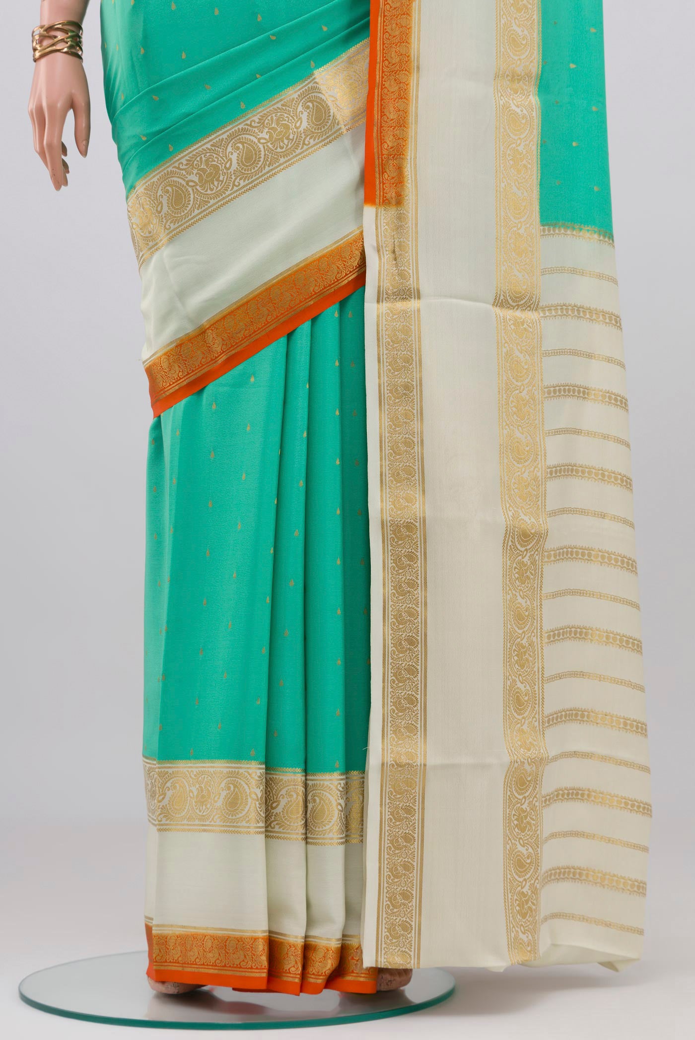 Pleats and pallu of Turquoise Mysore Crepe Saree with Zari Butta on the body and Zari Border. 