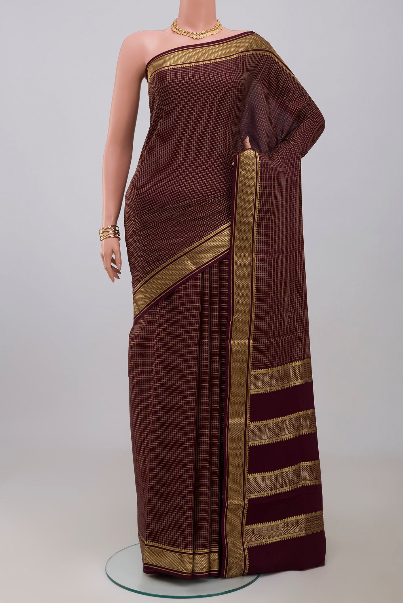 Purple Crepe Saree with Checked design on the body and Zari Border.  displayed on a mannequin