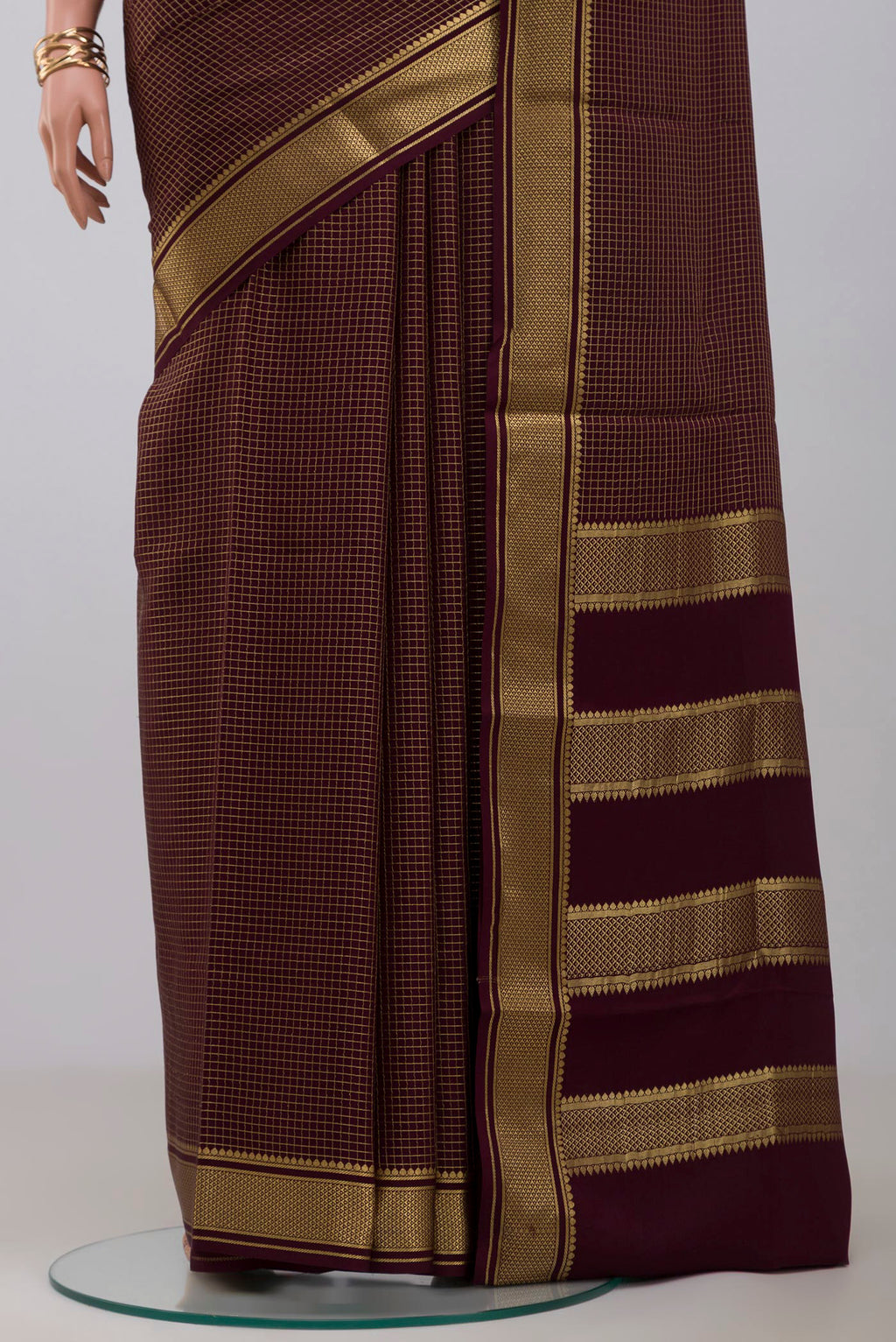 Pleats and pallu of Purple Crepe Saree with Checked design on the body and Zari Border. 
