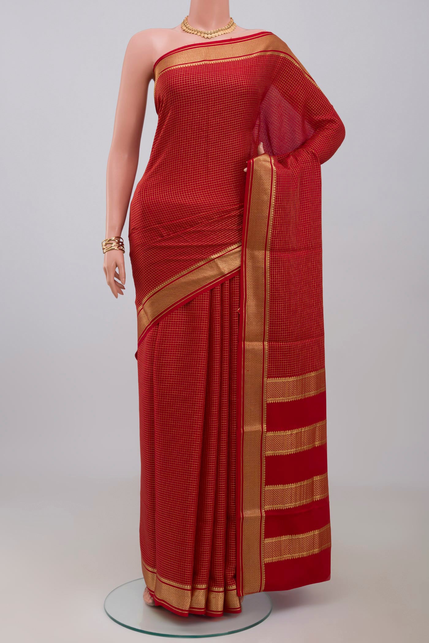 Red Crepe Saree with Checked design on the body and Zari Border.  displayed on a mannequin