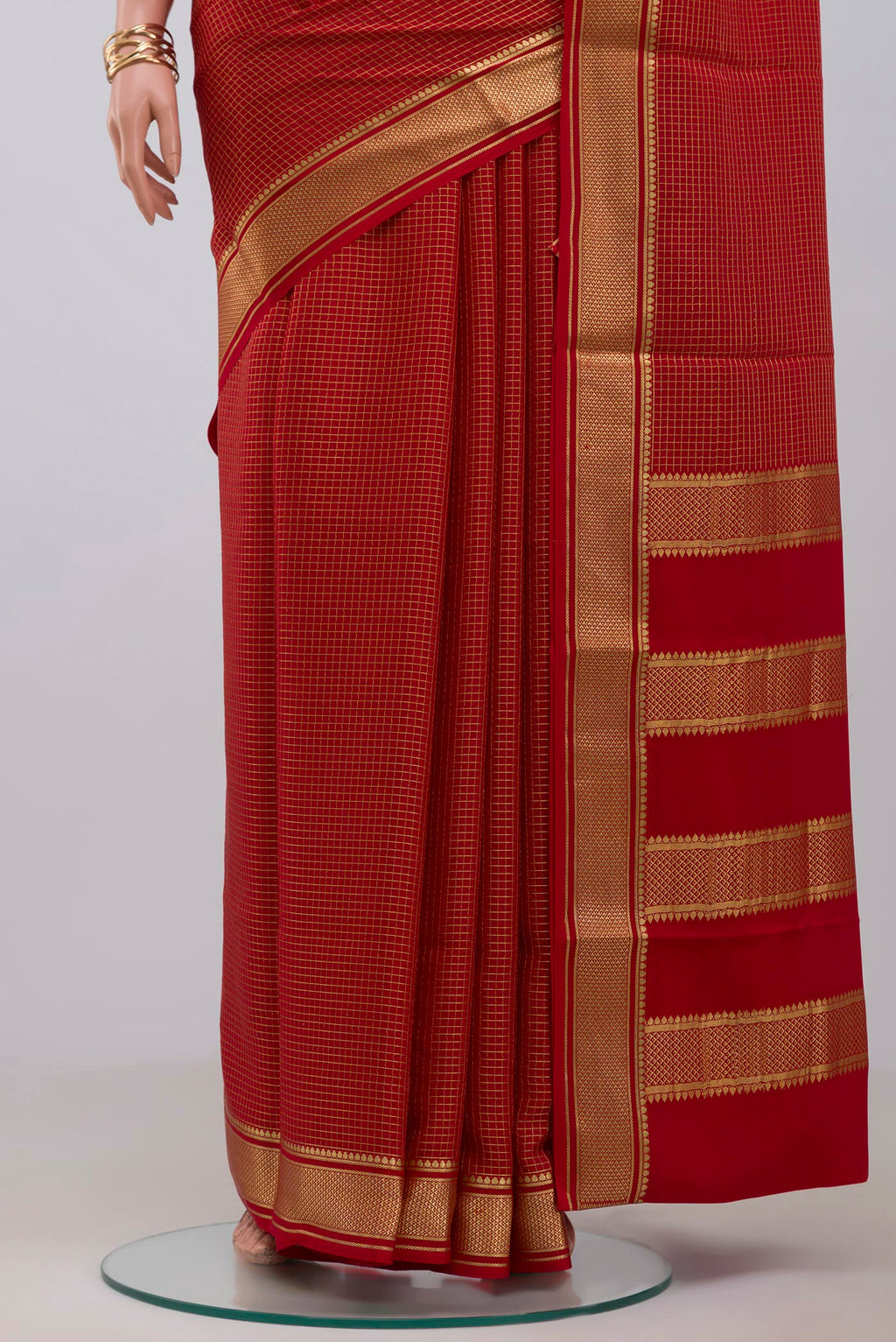 Pleats and pallu of Red Crepe Saree with Checked design on the body and Zari Border. 