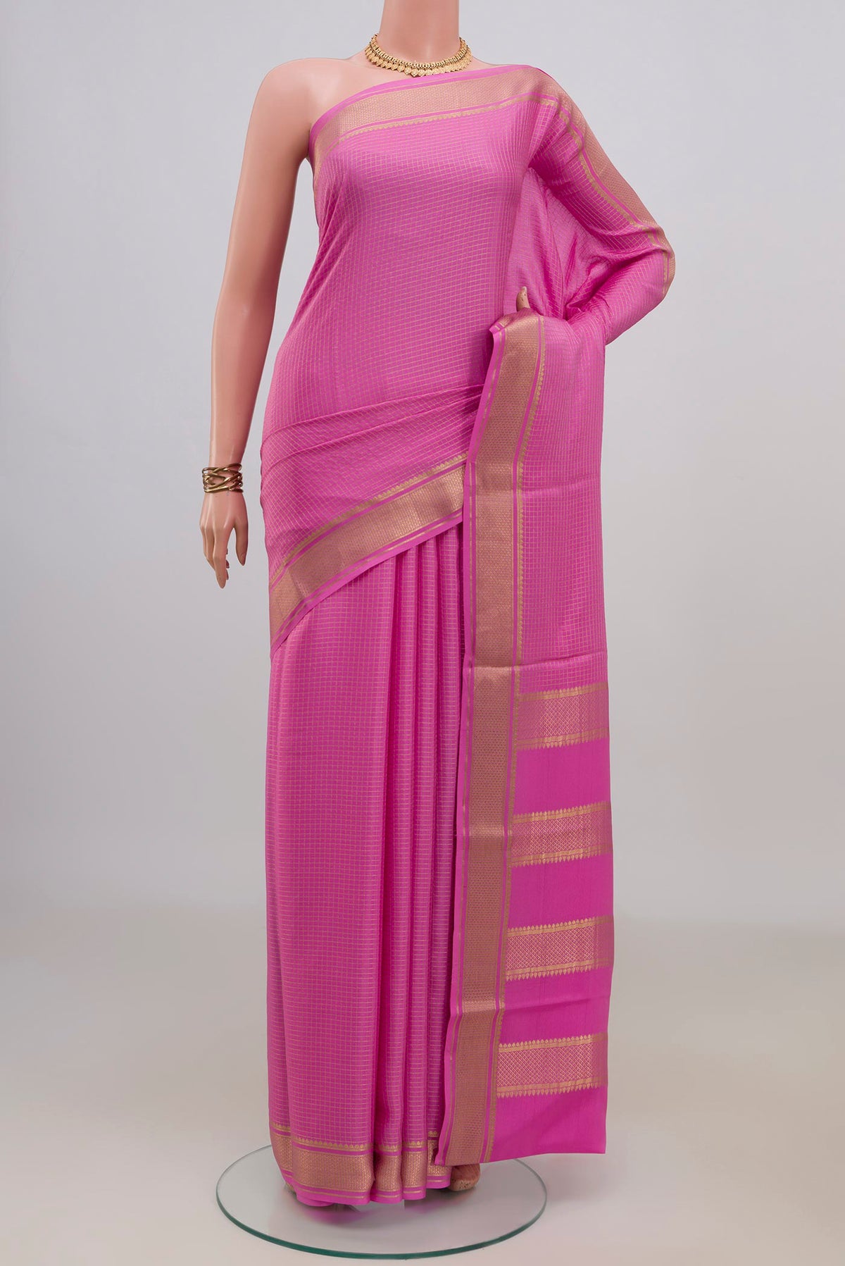 Pink Crepe Saree with Checked design on the body and Zari Border.  displayed on a mannequin