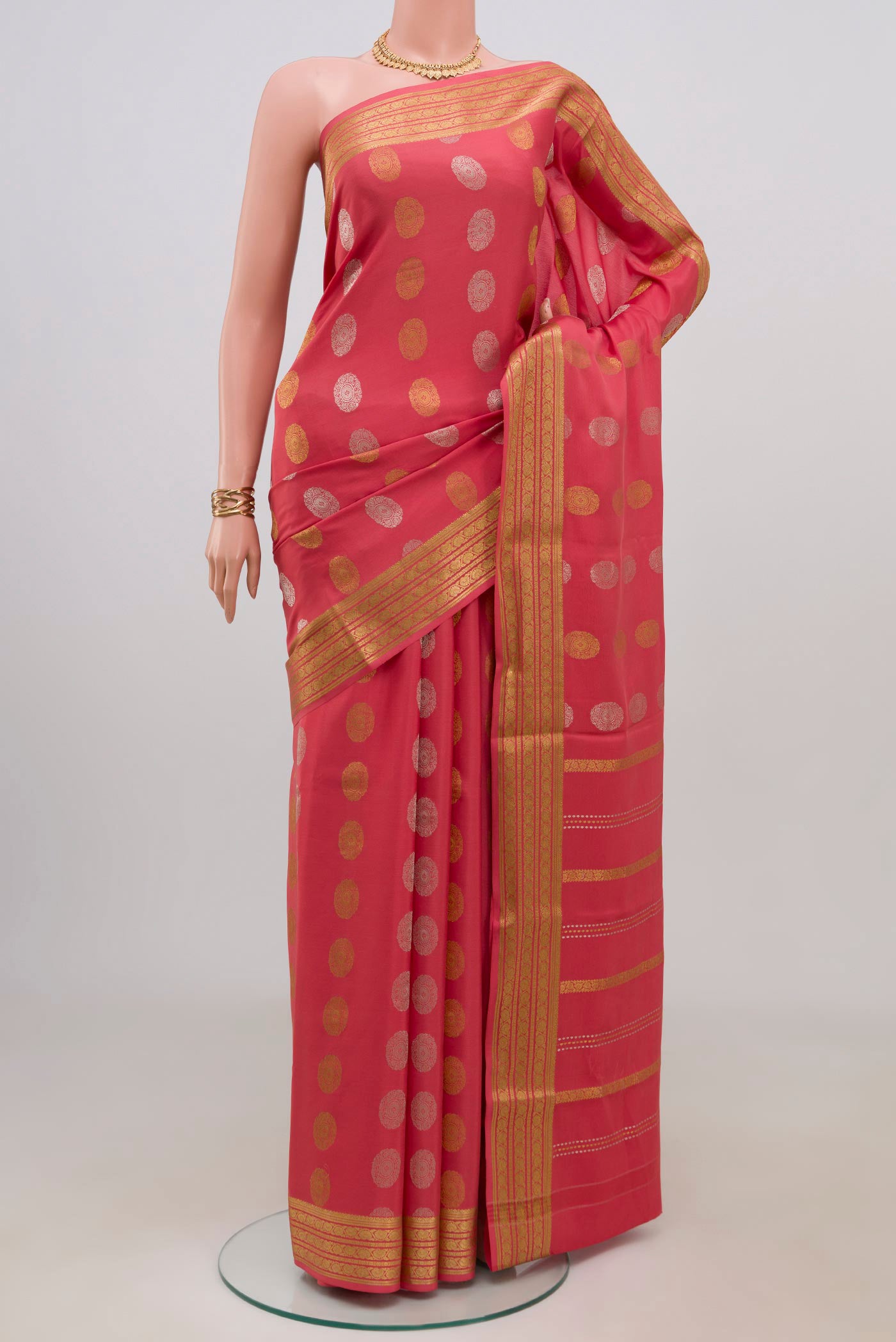 Peach Crepe Saree with Zari Butta on the body and Zari Border.  displayed on a mannequin