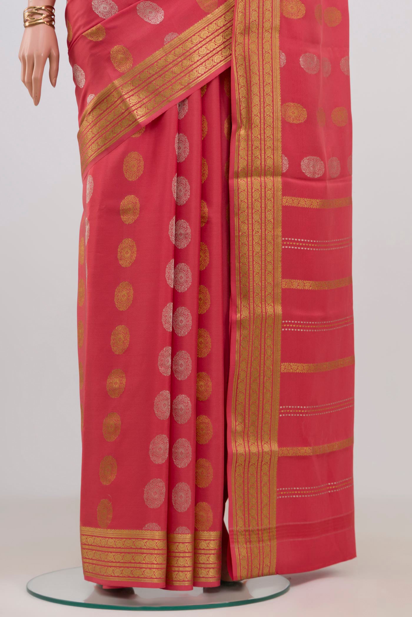 Pleats and pallu of Peach Crepe Saree with Zari Butta on the body and Zari Border. 