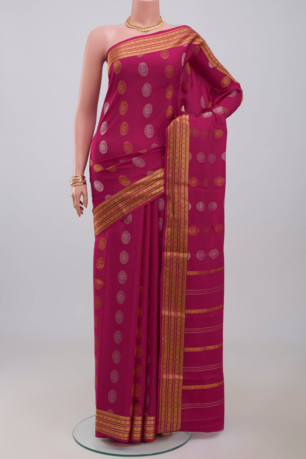 Pink Crepe Saree with Zari Butta on the body and Zari Border.  displayed on a mannequin